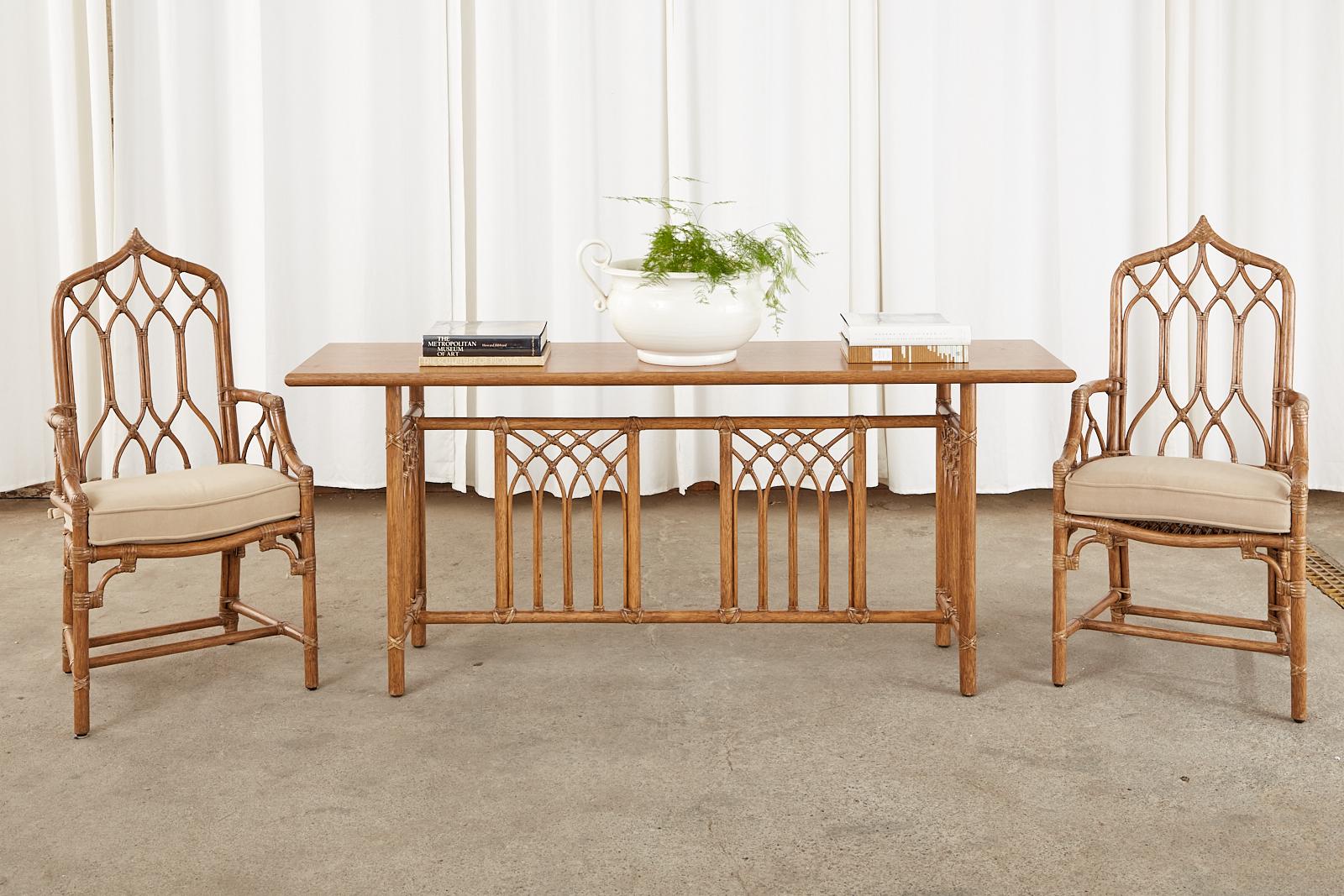 Distinctive set of six bamboo rattan dining chairs made by McGuire in the California organic modern style. The chairs feature gorgeous rattan frames with a gothic or moorish peaked crest and arched lancet designs on the splat. The set consists of