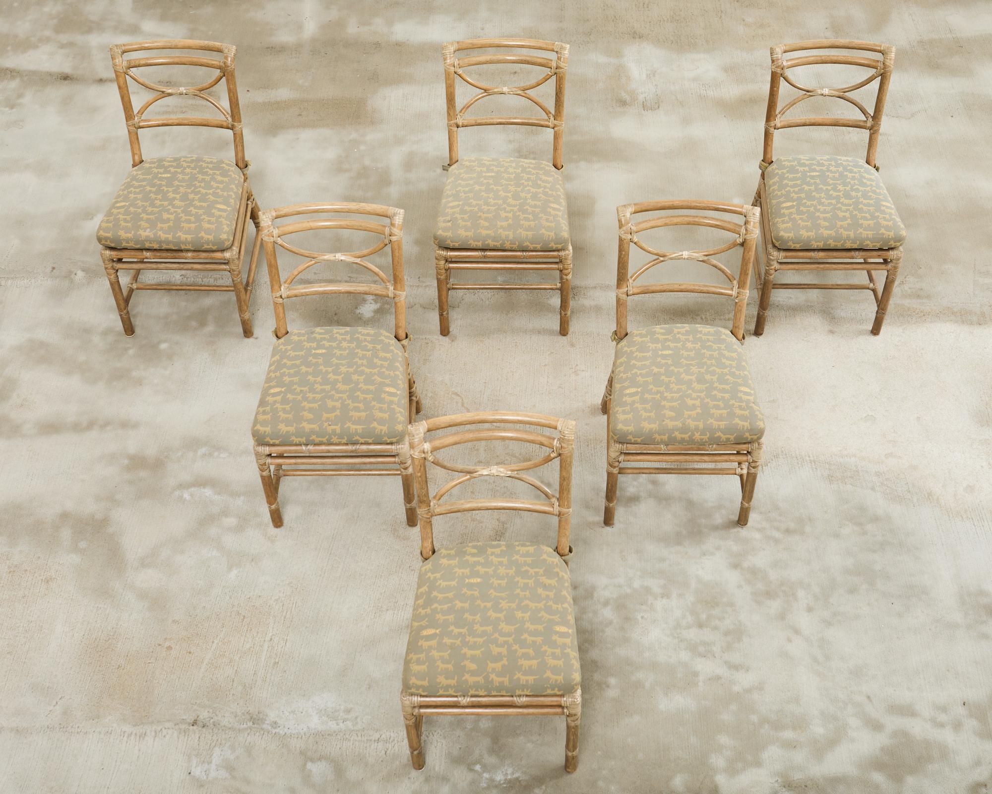 Elegant set of six rattan dining chairs made in the California coastal organic modern style by McGuire artisans. The set features a square pole rattan frame with curved backs and demilune form splats. The rattan is lashed together with leather