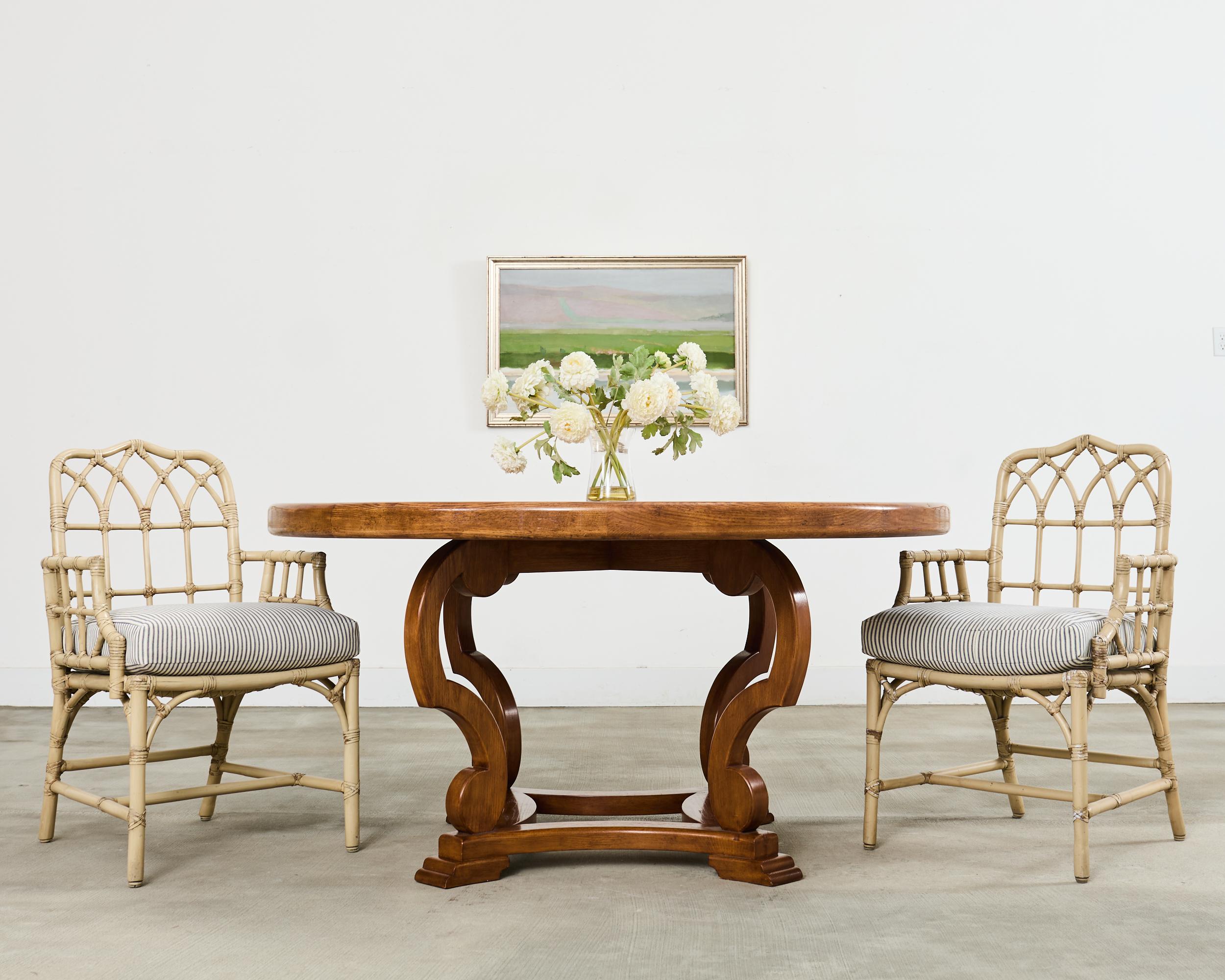 Distinctive set of six rattan dining armchairs made in the California coastal organic modern style by McGuire artisans. The chairs featuring a thick pole rattan frame decorated with gothic-inspired lancet arch cathedral designs on the backs and