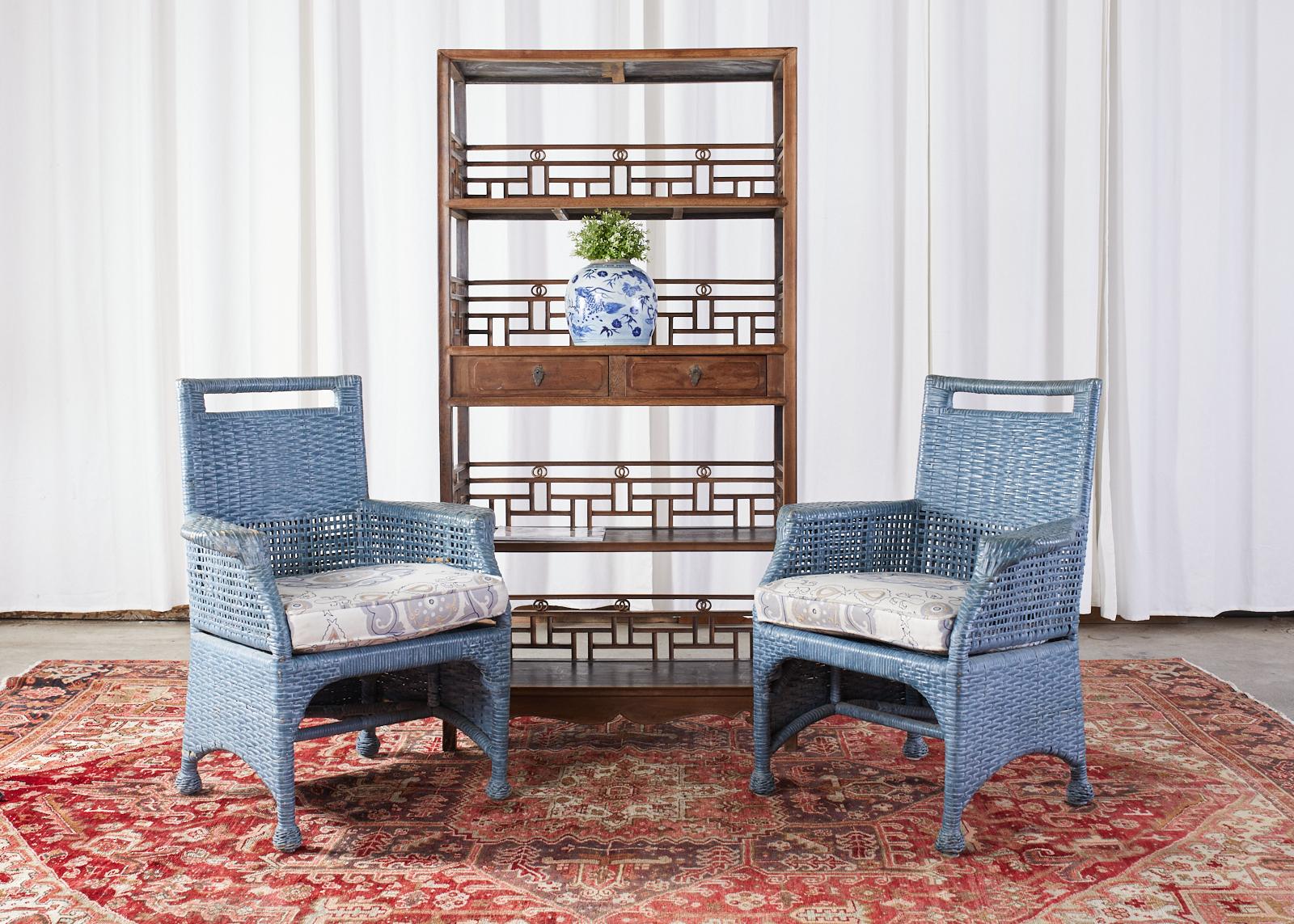 Organic modern set of six woven rattan and wicker dining chairs featuring a bespoke French blue painted finish by McGuire. The set consists of four side chairs and two armchairs with generous flat arms measuring 28 inches wide. Beautifully crafted