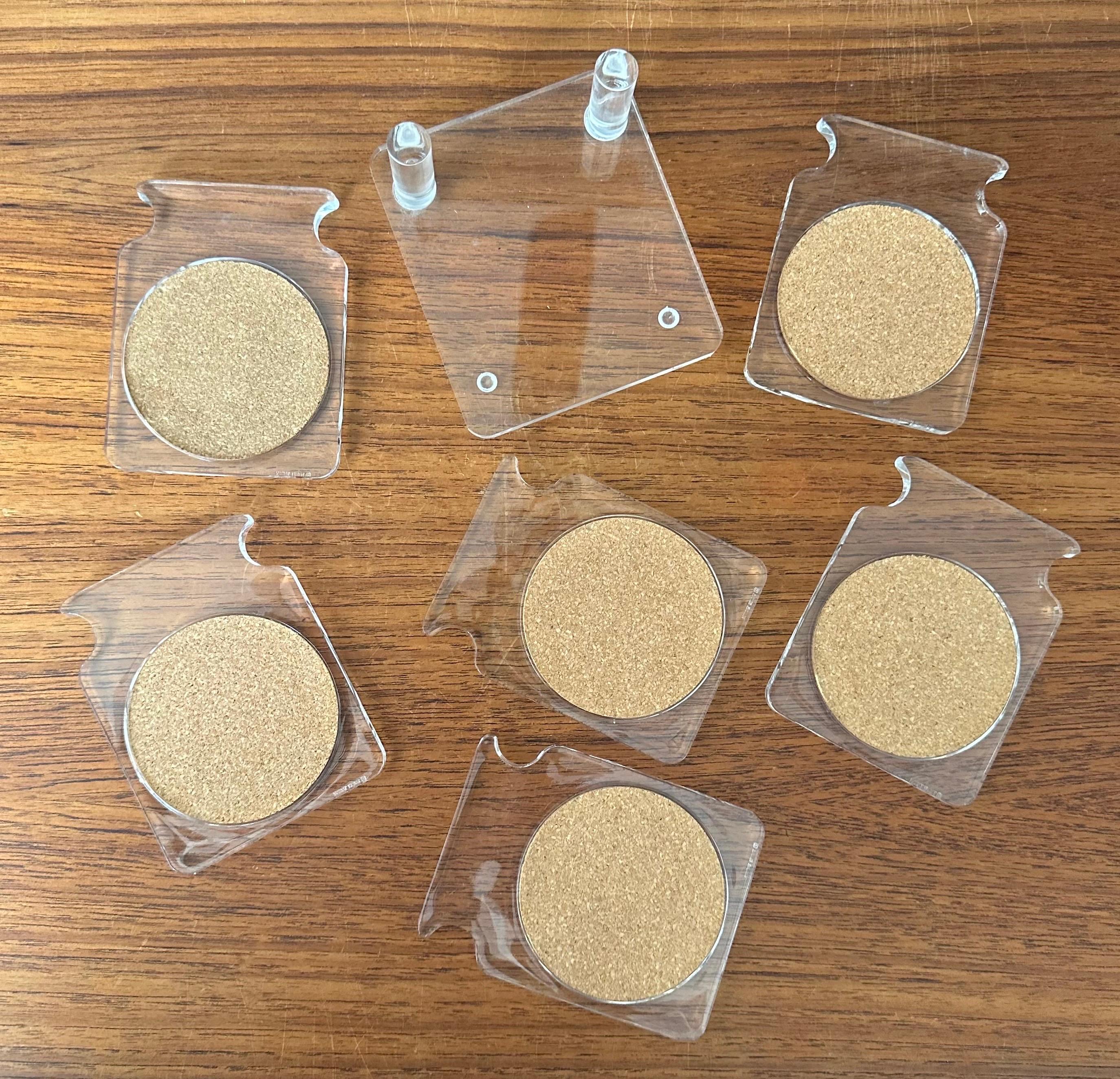 A nice set of six Lucite drink coasters and holder, circa 1970s. The coasters have a cork lining and are in very good vintage condition; the set measures 4.25