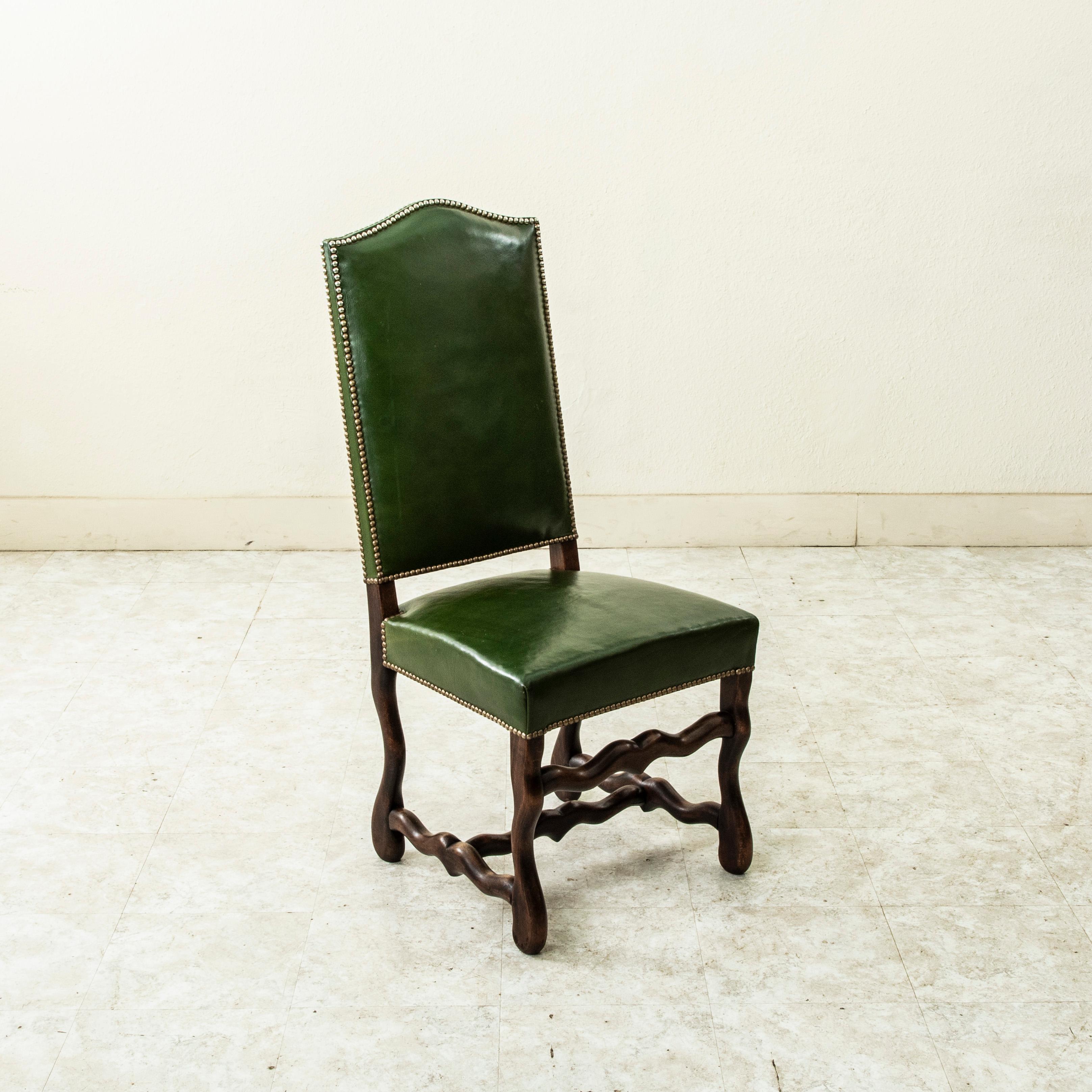 Cet ensemble de six chaises d'appoint ou chaises de salle à manger en chêne français, datant du milieu du XXe siècle, est fabriqué à la main. Ces chaises de salle à manger hautes à dossier arqué sont revêtues de cuir vert et finies avec une