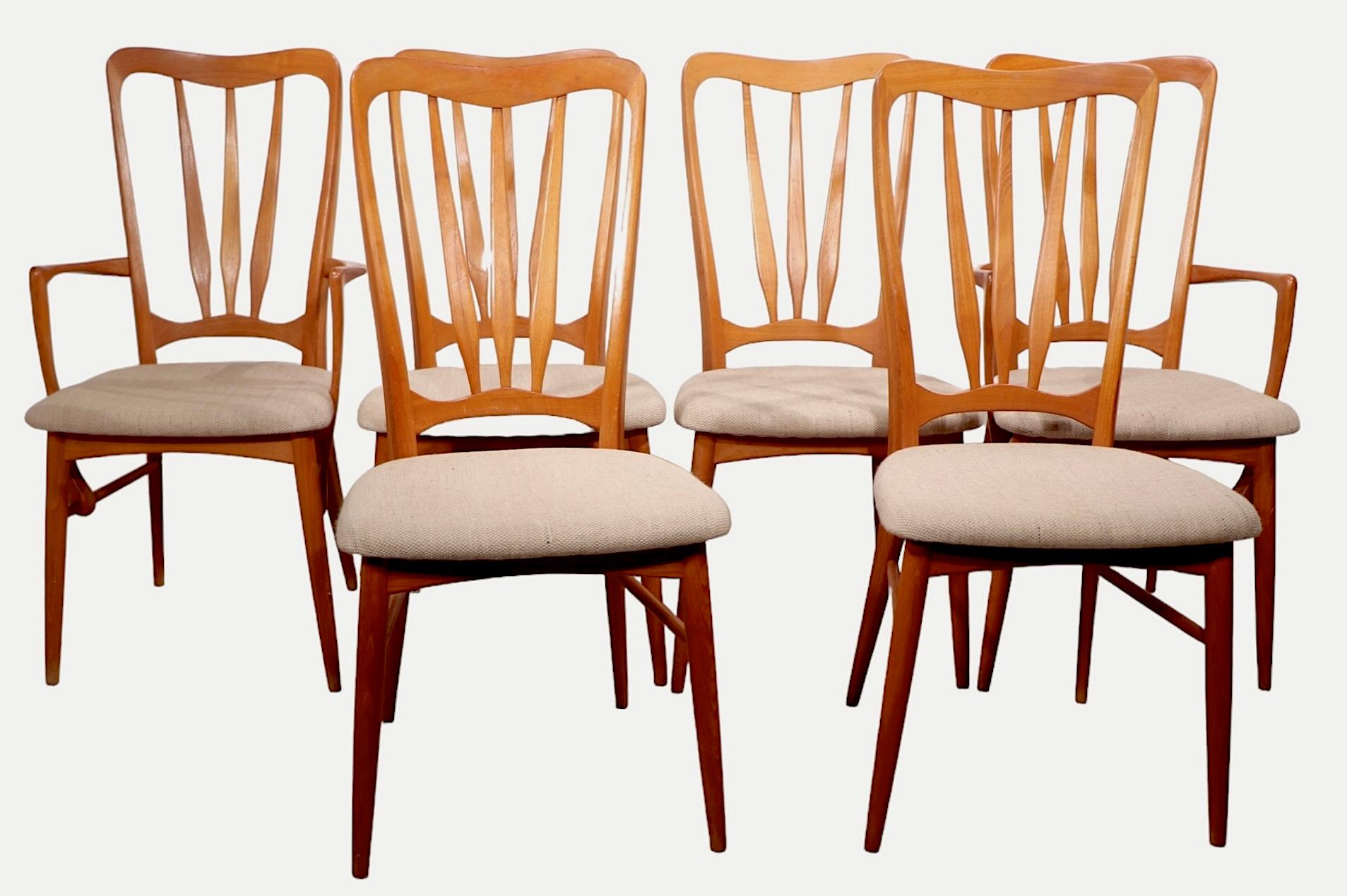 Rare set of Danish Modern Ingrid model dining chairs made by Koefoeds Hornslet circa 1960's. The set consists of four side, and two arm chairs, constructed of solid teak, with original beige tweed upholstered seats. 
 Sophisticated sculptural form,