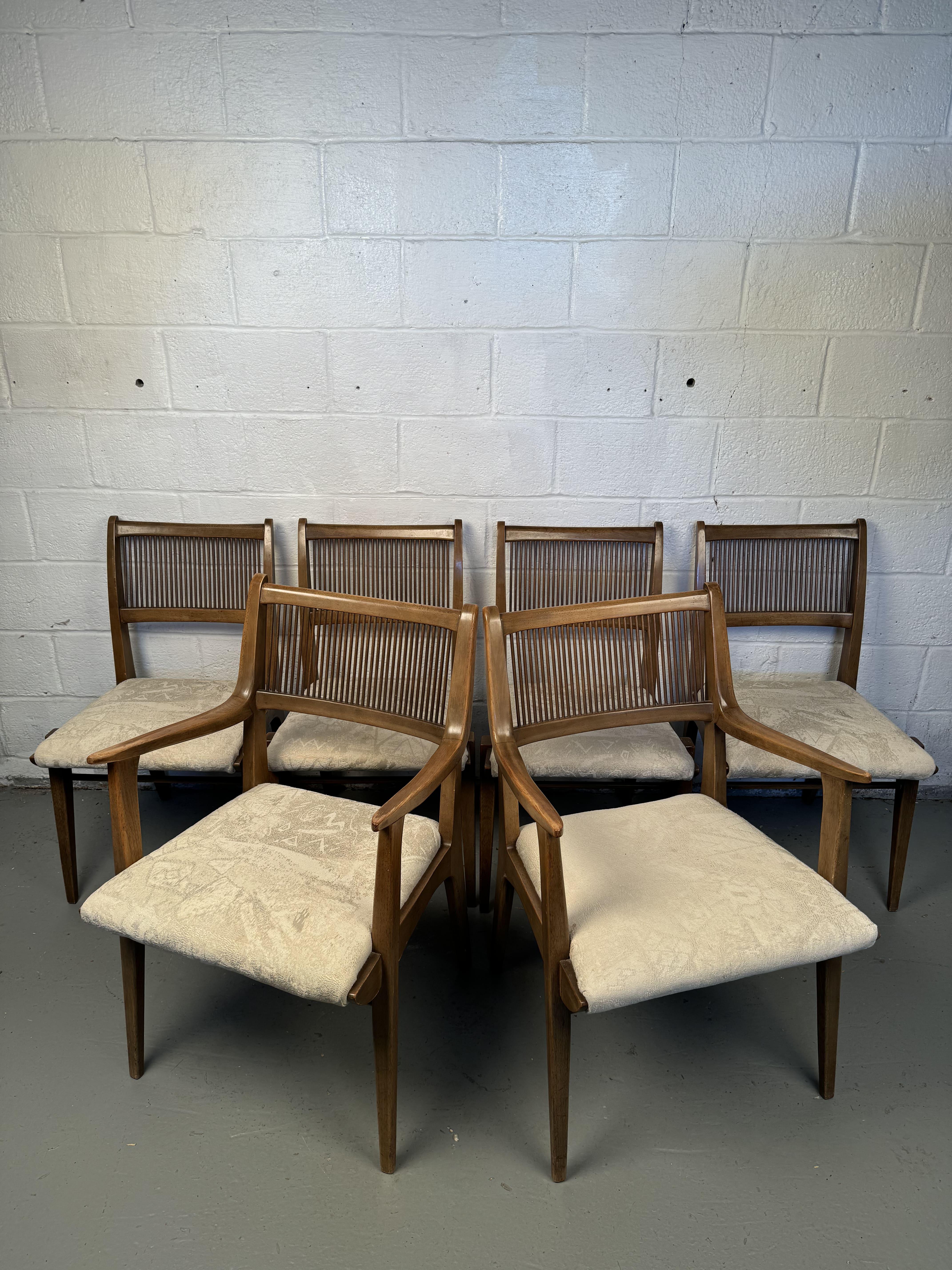 Exquisite set of mid century dining chairs, designed by John Van Koert for the classic Profile series, made by Drexel. Circa 1950's. The chairs feature a sculpted frame of solid walnut, with spindle backs, and upholstered seats. The set consists of