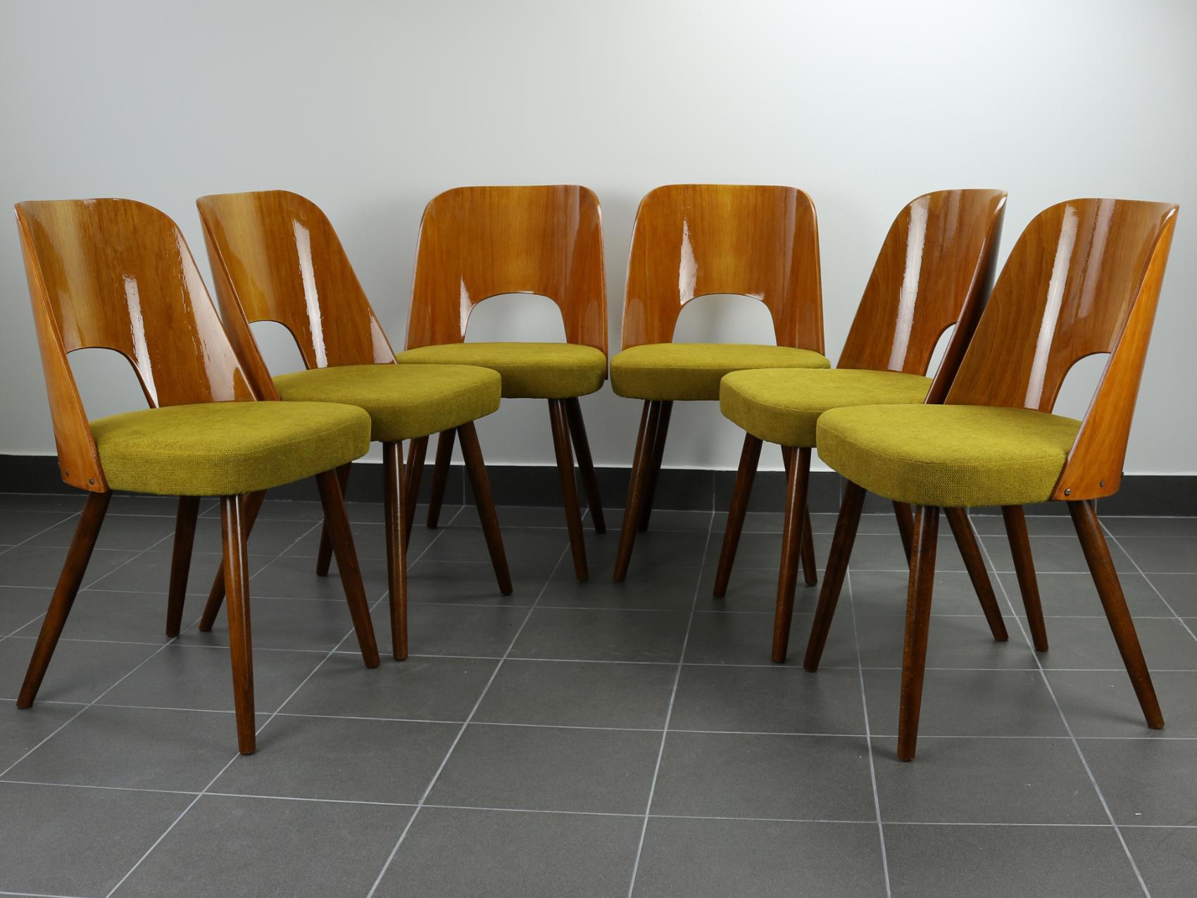 This set of six dining chairs was designed by Oswald Haerdtl for Thonet in 1955. The chairs are made of bent beech plywood formed structures and round tapered wooden legs. Fully restored with new upholstery.