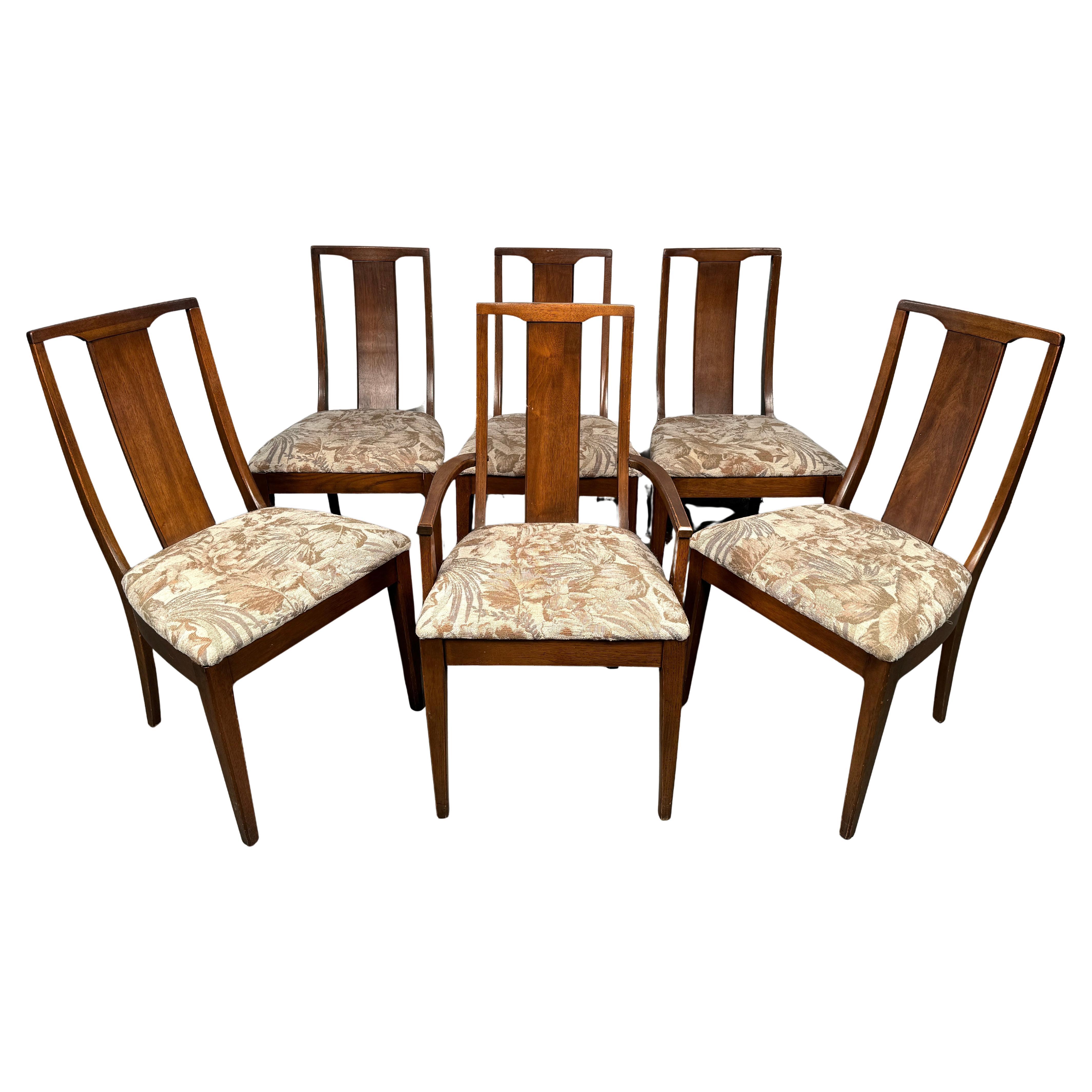 Elevate your dining space with this beautifully crafted set of six mid-century dining chair set, complete with a stately captain’s chair for added presence and comfort at the head of the table. This timeless set features the clean lines, sculptural