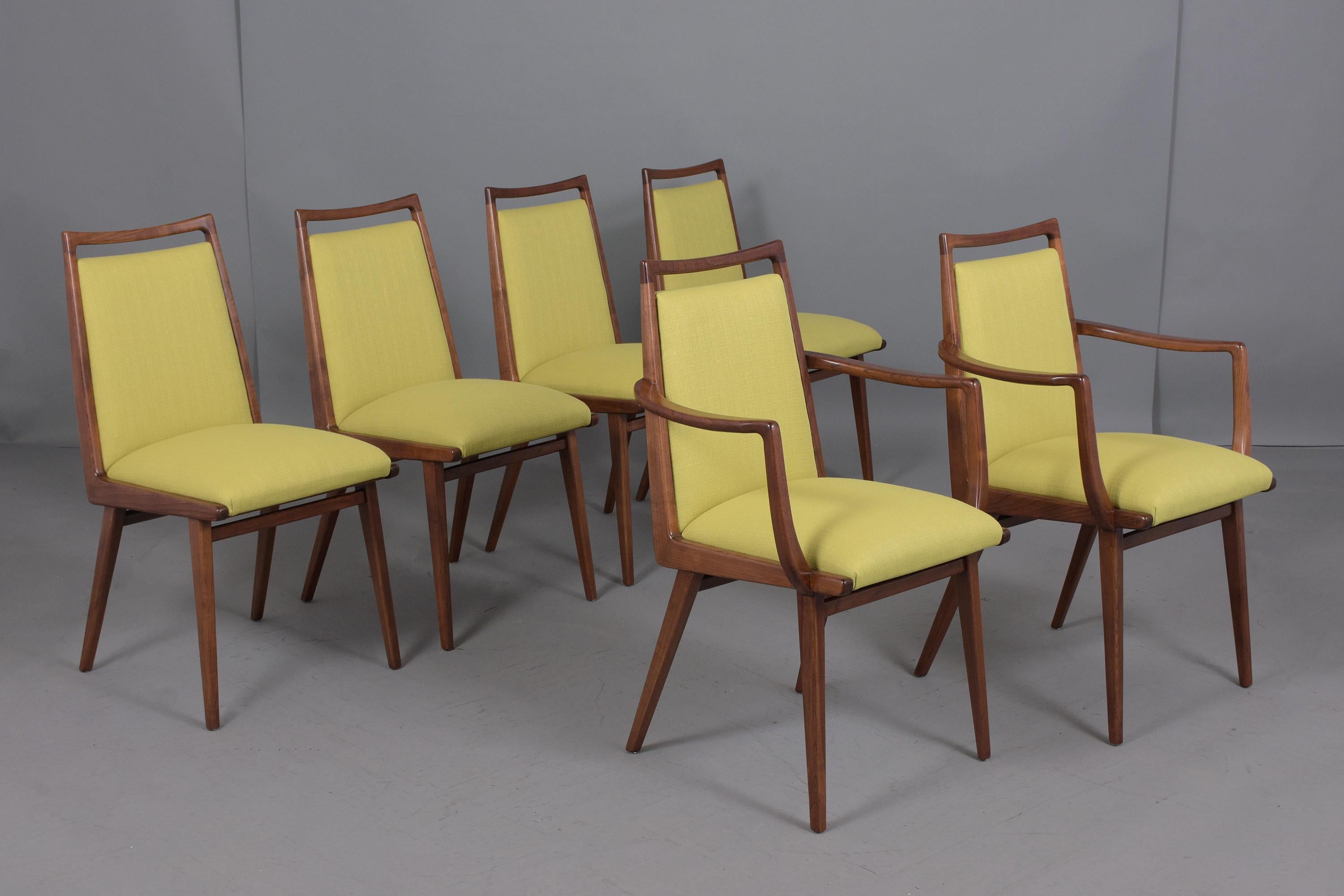 An exceptional set of six mid-century modern dining chairs hand-crafted out of walnut wood in great condition professionally refinished and upholstered by our craftsmen. This set of chairs features two armchairs, four side chairs with a sleek carved