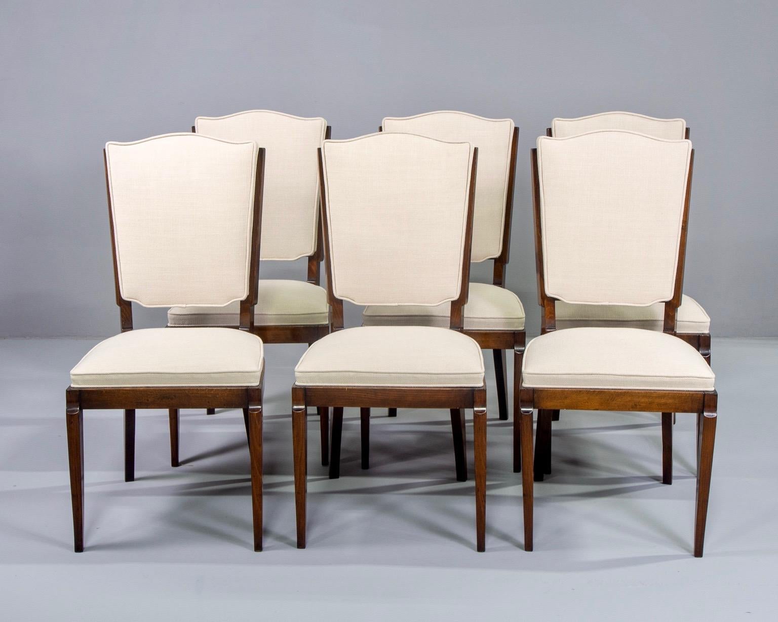 Set of six circa 1950s French dining chairs. Beech frames have been professionally polished and there is new natural color linen-blend upholstery on seats and backs. Unknown maker. Quality construction includes spring foundation in seats. Sold and