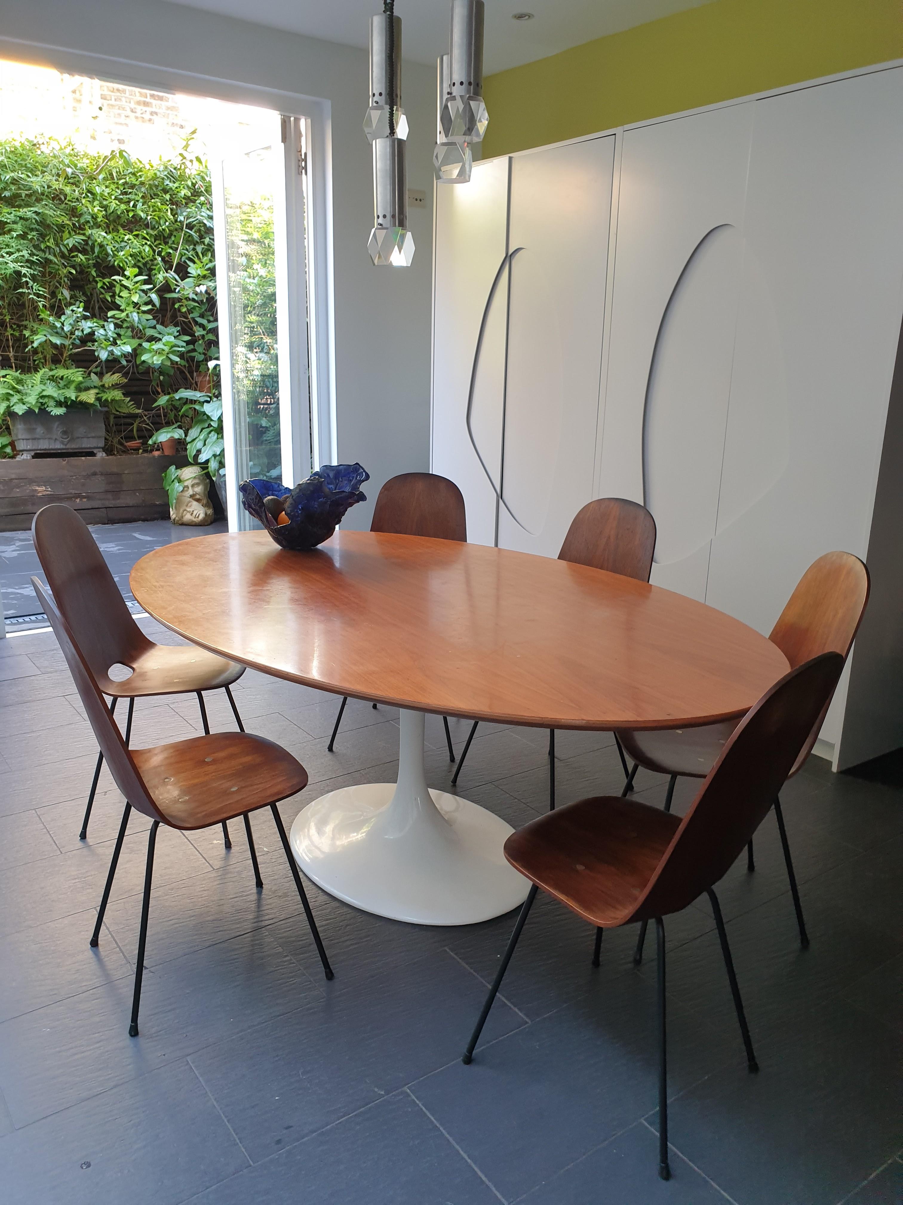 Set of six Modernist dining chairs with curved backs and lacquered metal legs, designed by Franco Campo and Carlo Graffi. These quality chairs have Rio rosewood veneer and brass studs. They are light and easy to transport due to the convenient cut