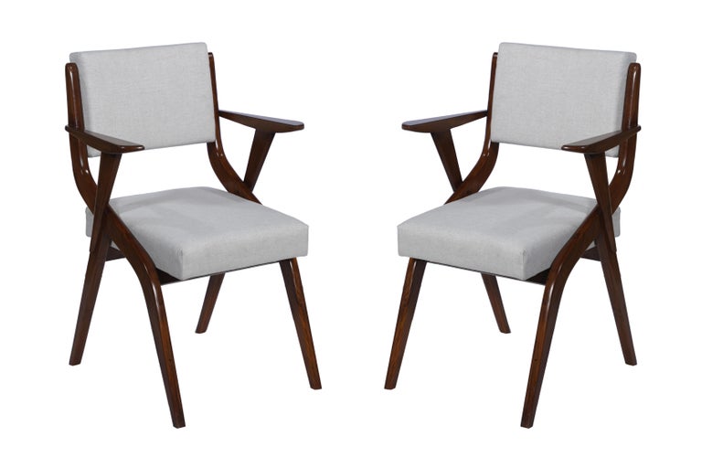 A handsome set of six Danish, Mid-Century Modern teak dining chairs with arm rests. They have been reupholstered and refinished. Fabric is a silk and linen blend with new cushions, and the chairs look great from behind as well. The arm rests are