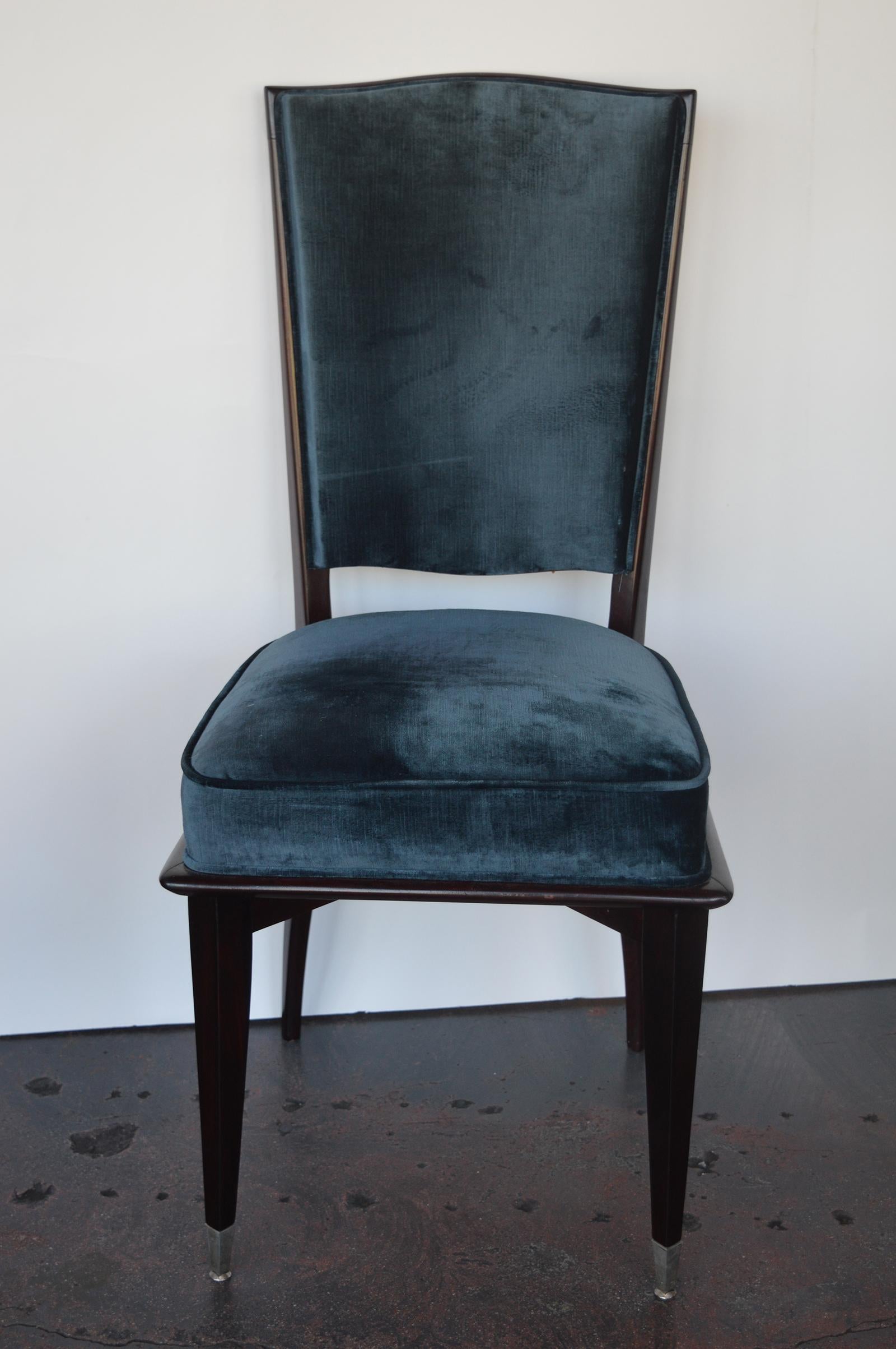 Set of six Mid-Century Modern dining chairs. Newly upholstered in a dark peacock color that compliments the mahogany on the chairs. The two front feet are accented with chrome caps.