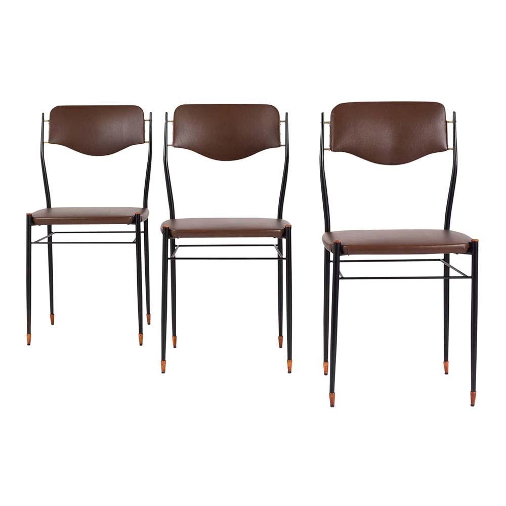 These 1960s six mid-century modern dining chairs have been professionally restored by our team of craftsmen and are in very good condition. This set features a sleek metal frame painted in black with wood finials on the seat and carved wood feet.