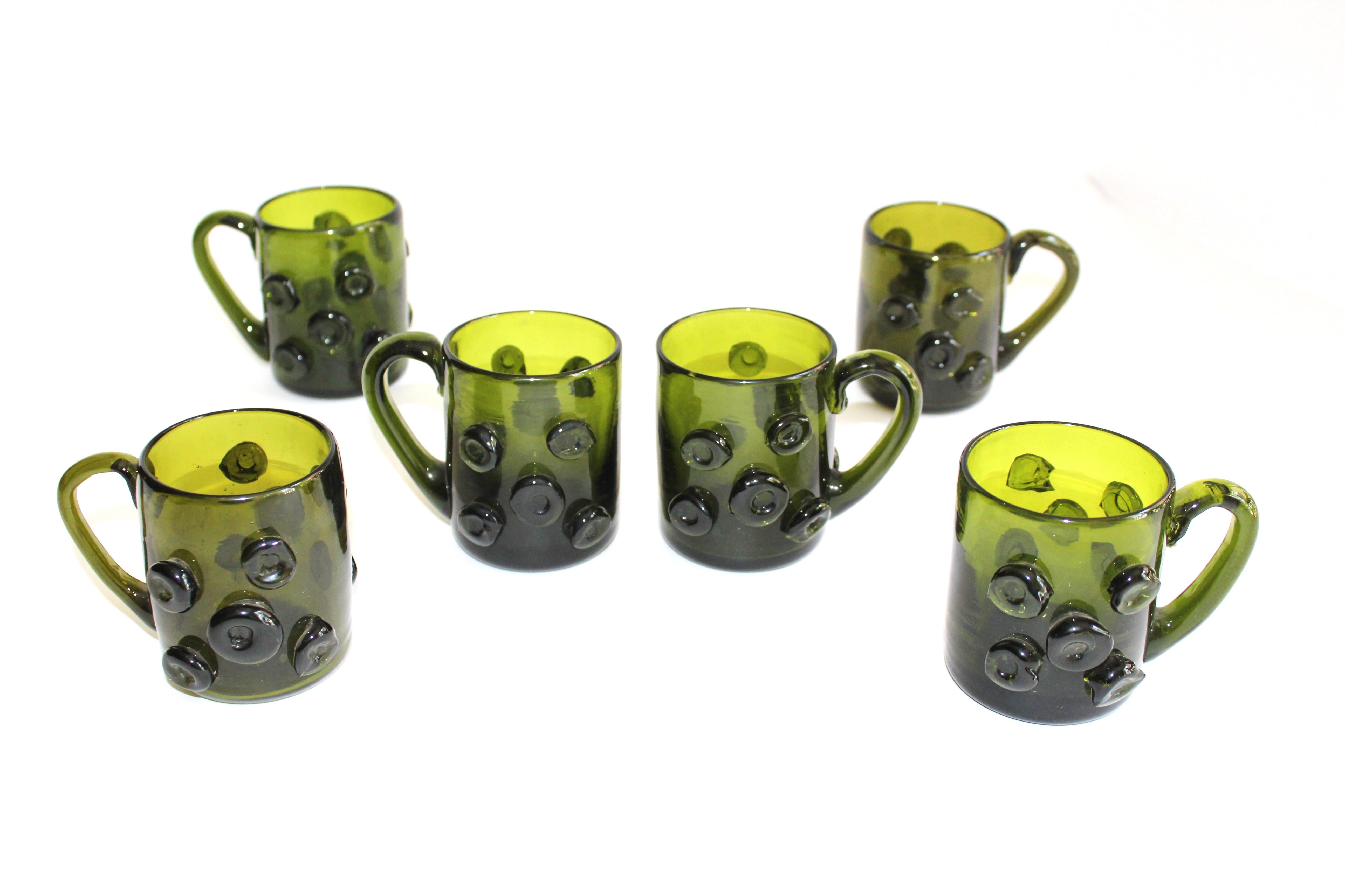 Set of six charming Mid-Century Modern handblown glass mugs in beautiful emerald green. Large demitasse size perfect for espresso or liqueurs. The glasses feature circular prunts along the exterior, as well as Fine sculpted glass handles.