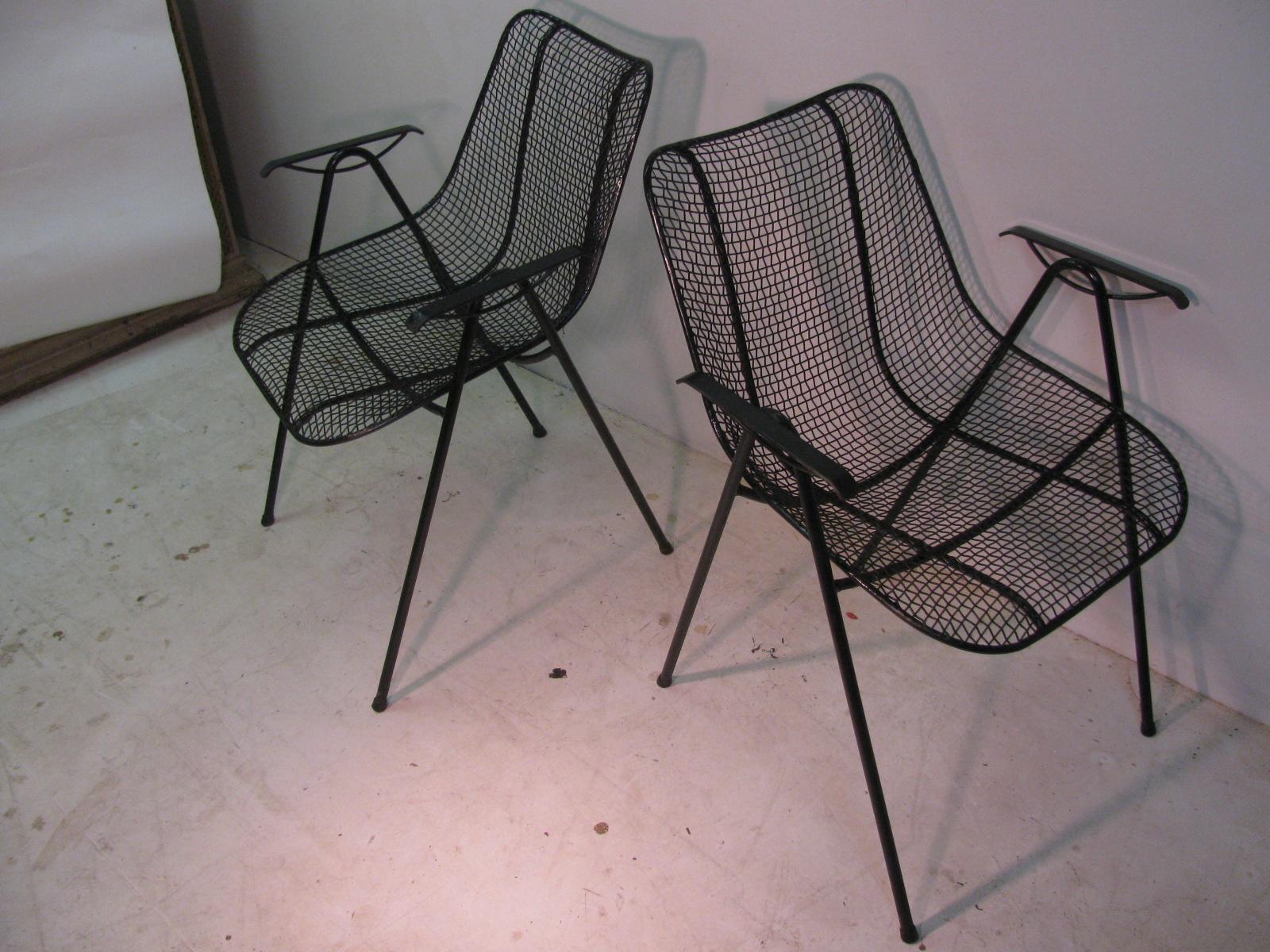 Fabulous set of eight Russell Woodard sculptura wire mesh chairs with armrests. Rare set, not very common. Very comfortable and in excellent condition, freshly sprayed black. Two chairs have ball feet which raise the height to 33in. and the seat