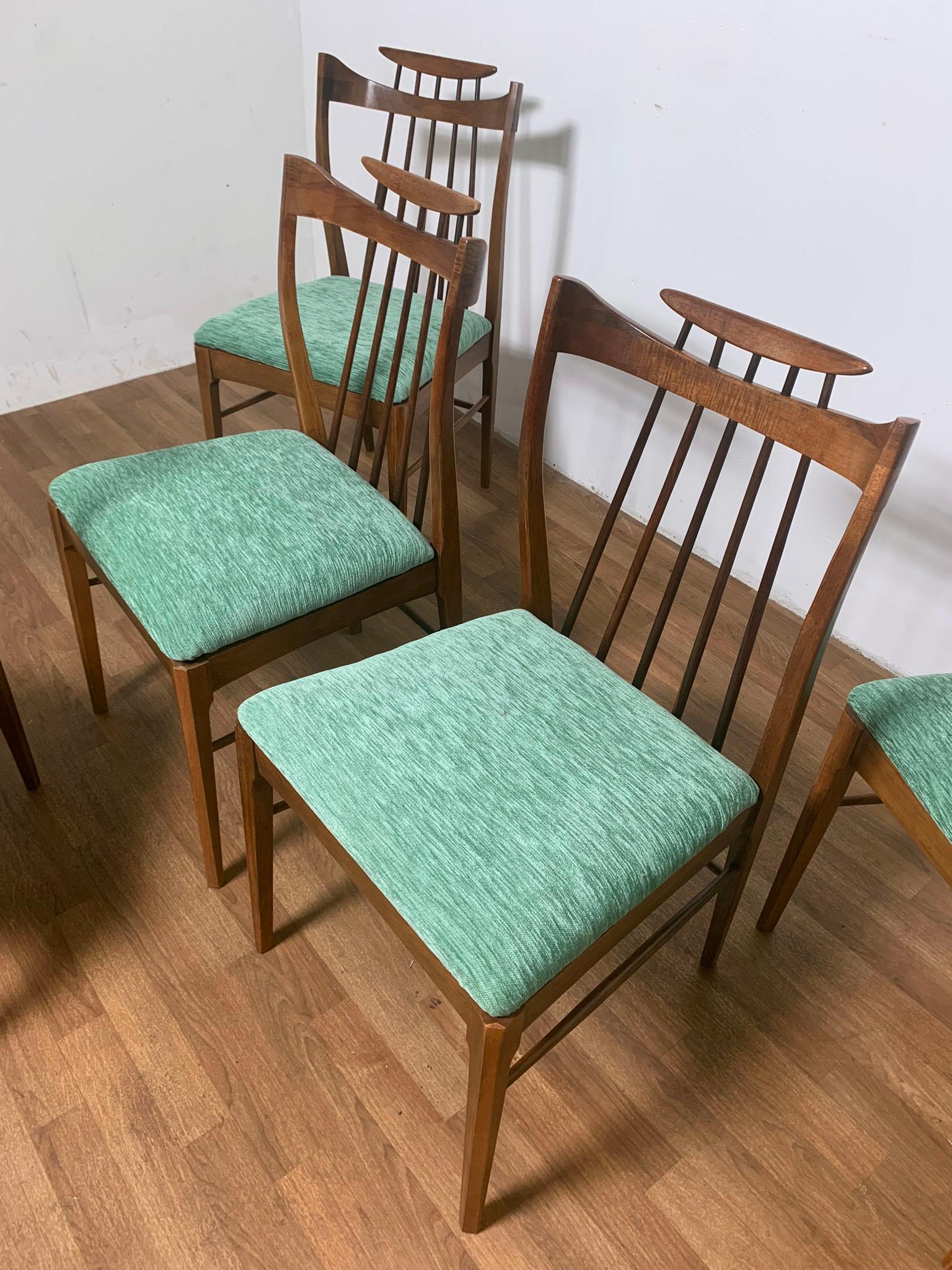 A set of six stylized walnut dining chairs by the American furniture maker Thomasville, ca. 1958.

Armchairs measure 24” wide, 22” deep, 33” high, seat height 17.5”.
Side chairs measure 18.5” wide, 22” deep, 33” high, seat height 17.5”.

