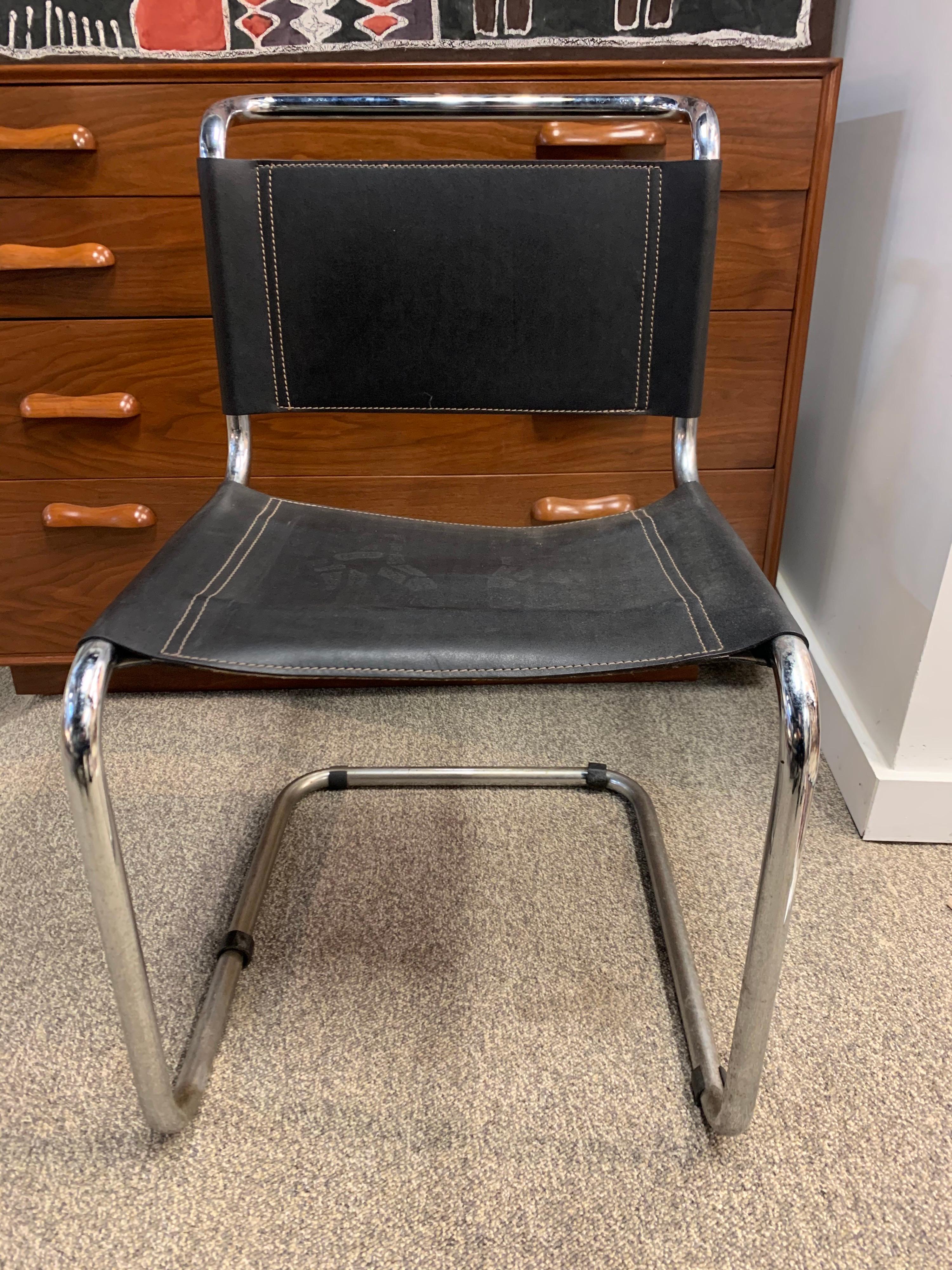 Iconic Mid-Century Modern tubular cantilever chairs with black seating surface, Circa 1970's and with normal age appropriate wear. Seating is some type of vinyl, not leather.