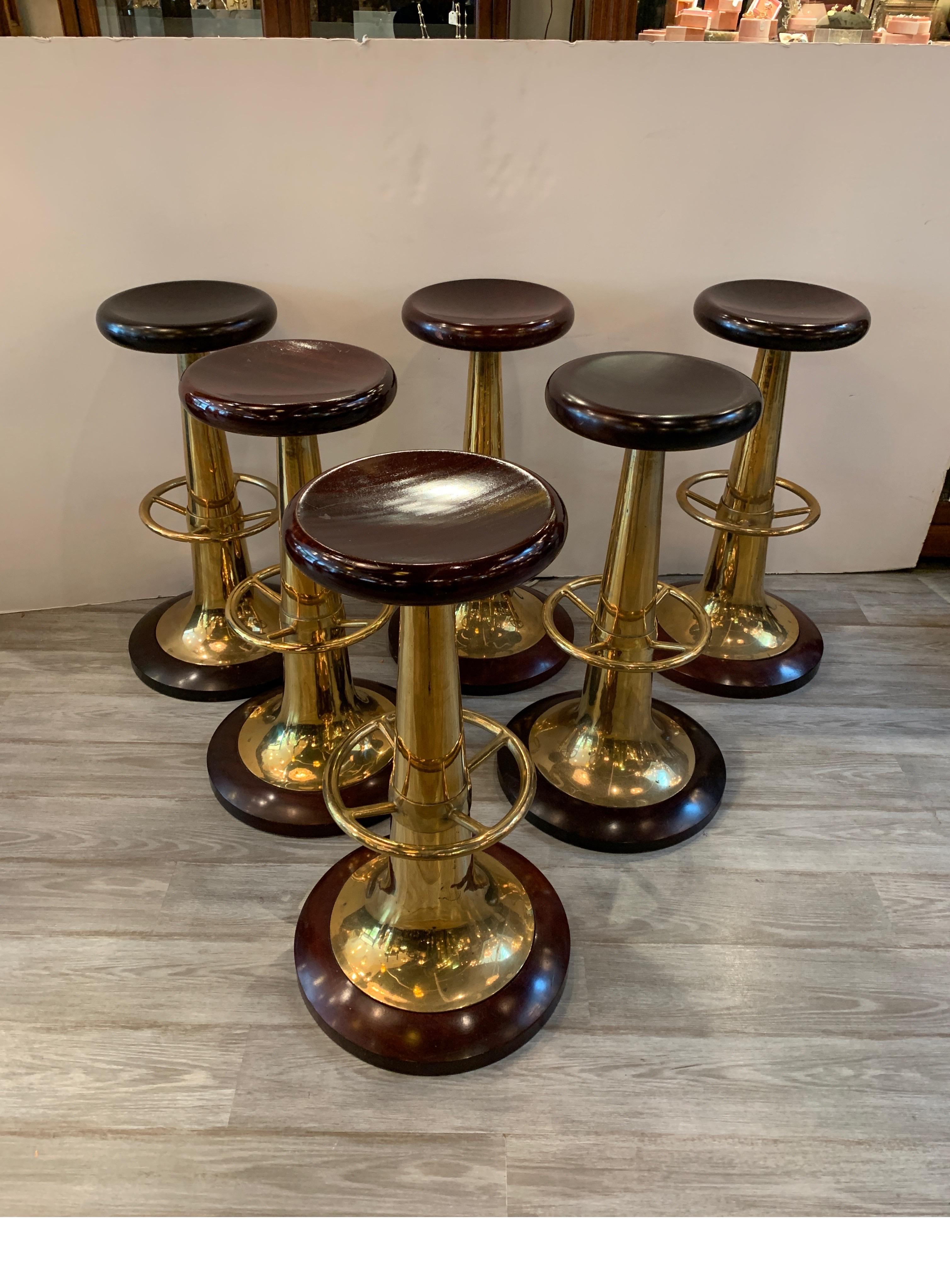 Set of six midcentury solid mahogany and brass nautical bar stools, the seats are solid mahogany with a comfortable dish form. Solid brass trumpet form pedestal column with a brass nautical form footrest. The base is also a thick solid piece of