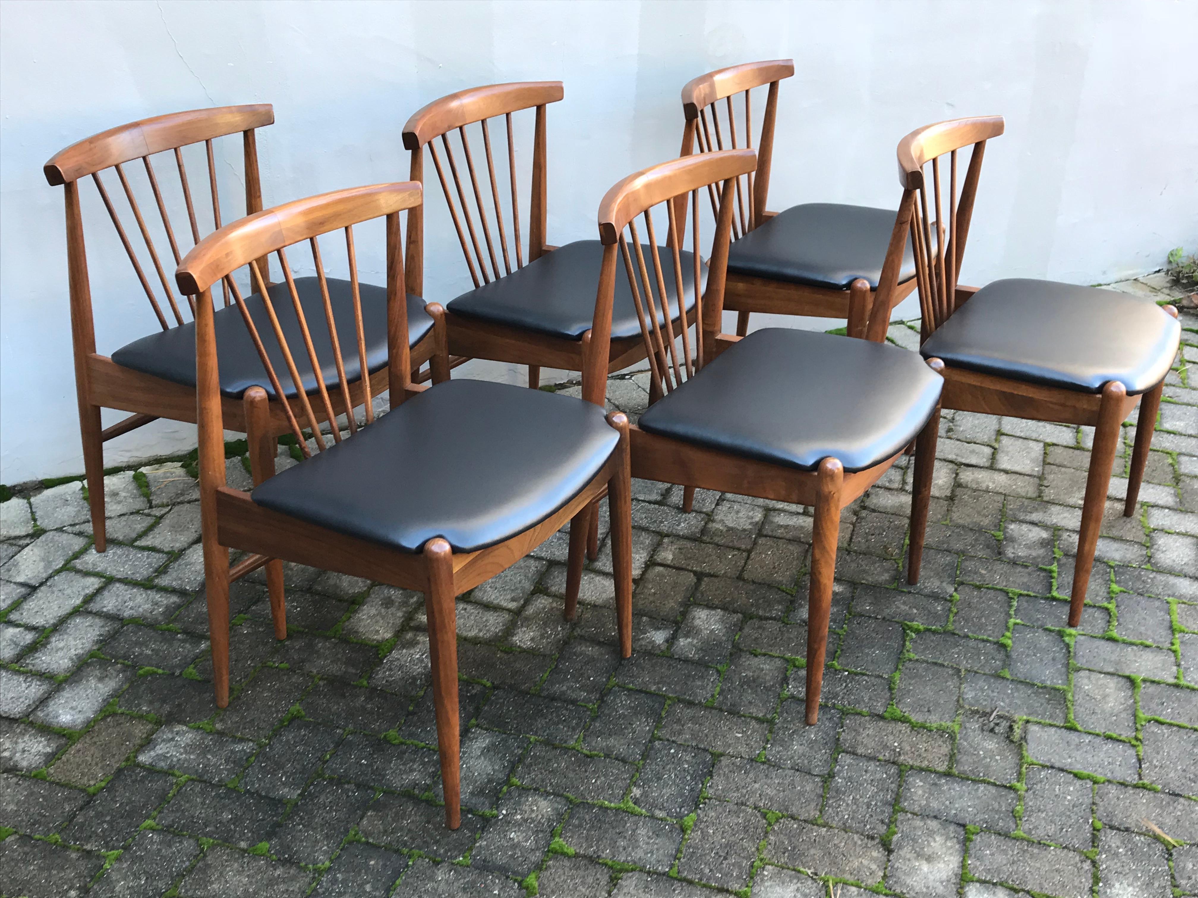 Beautiful set of six Mid-Century Modern dining chairs with spindle backs, recently reupholstered in high quality black vinyl.