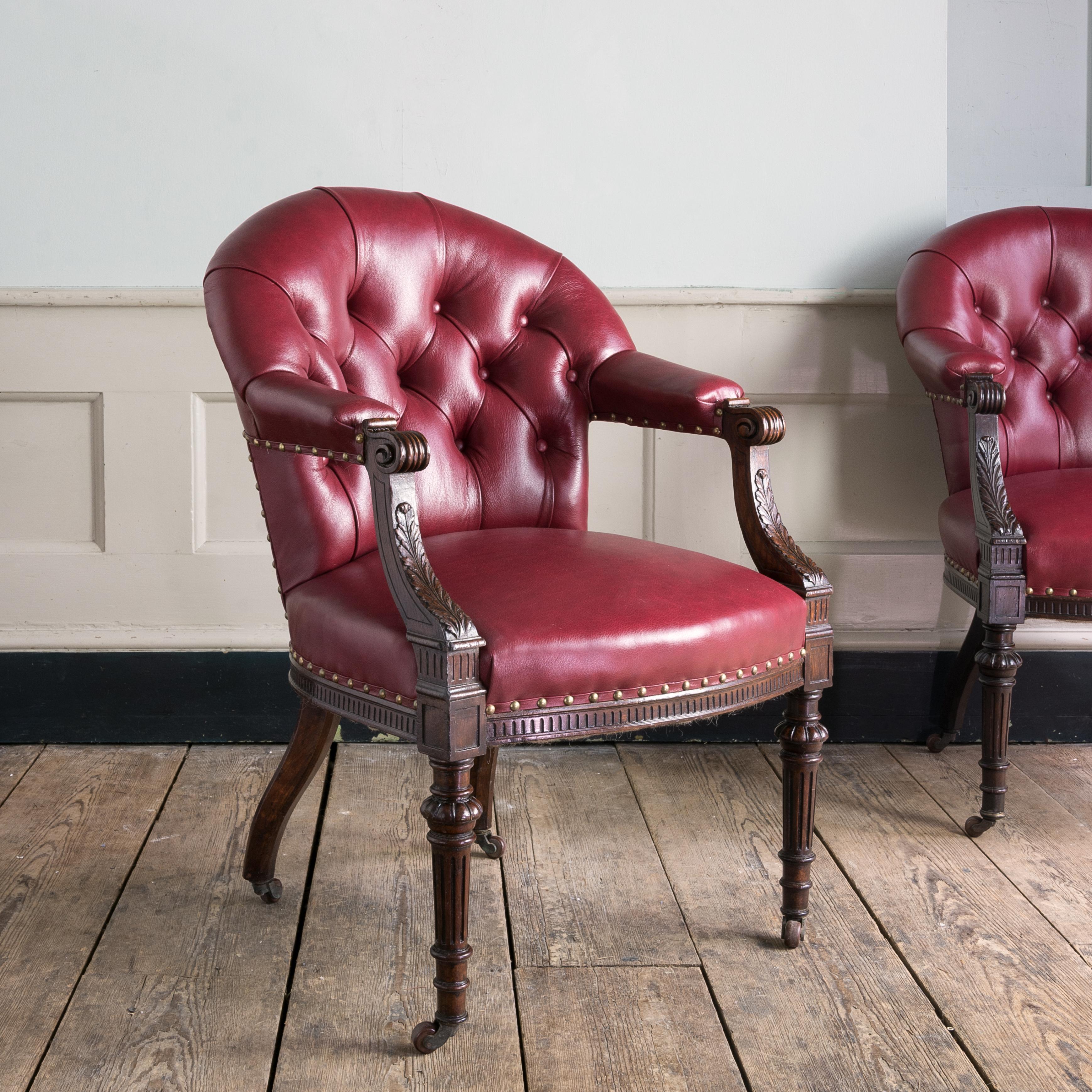 A fine set of six mid-Victorian carved oak and leather upholstered club armchairs, circa 1870-1880 in the French taste, with deep-buttoned back and scrolled arm rests with acanthus supports, the turned, tapered and fluted front legs with gadrooned