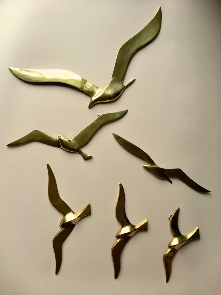 This wall decoration is made of polished brass, each bird is equipped with one or two hooks. 
The birds differ in sizes and can be exposed in any combination you like.
One bird has a sticker 