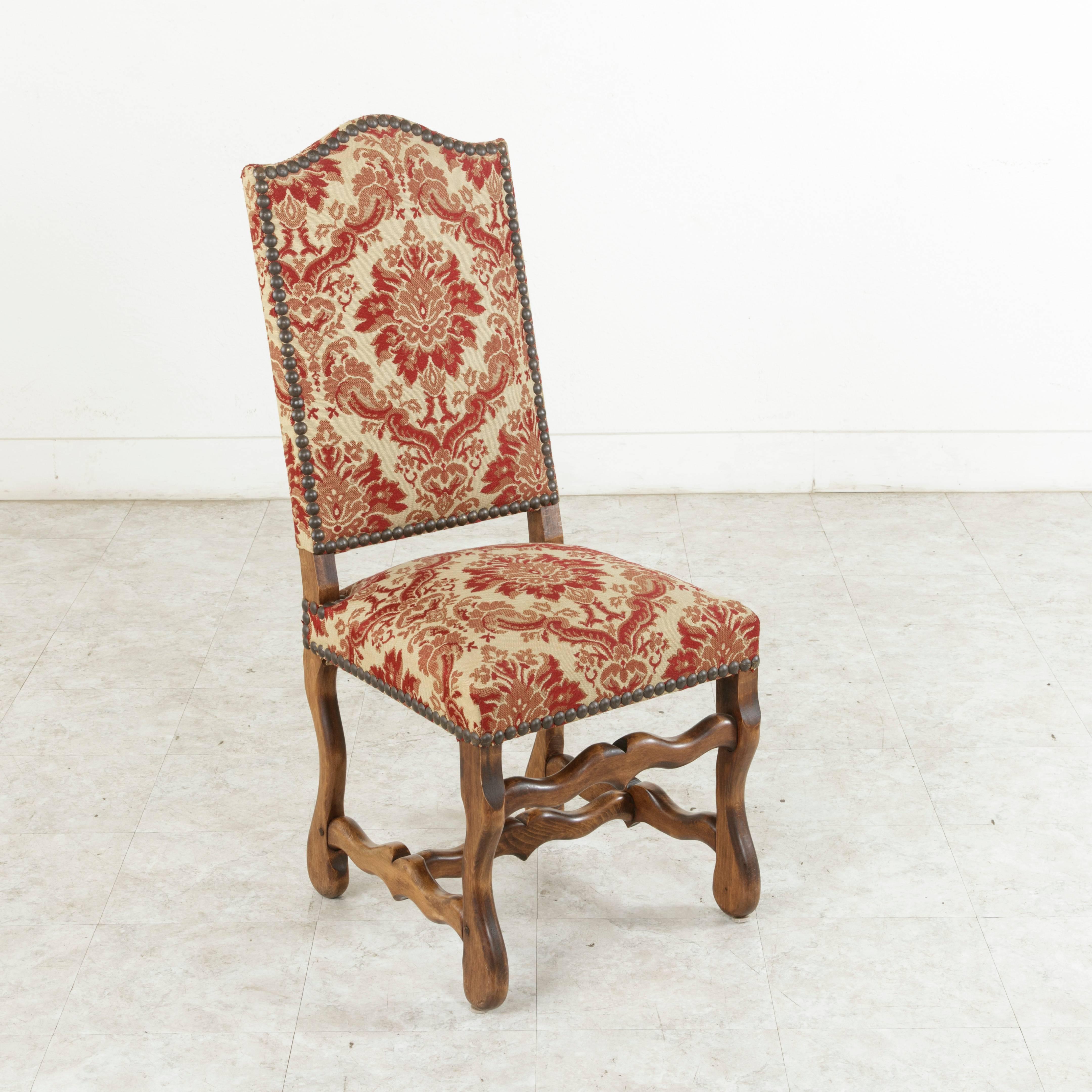 This set of six French ash mutton leg side chairs or dining chairs from the mid-20th century are of hand pegged construction and feature a rich aged patina. Upholstered in a red tapestry and finished with nailhead trim, these chairs are ready to be