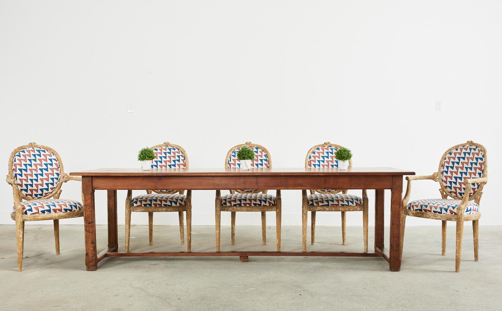 Magnificent set of six Mid-Century Modern Italian Regency dining armchairs featuring hand-carved faux bois twig frames. The set consists of six armchairs upholstered with a colorful geometric pattern fabric. The generous seat has flat armrests