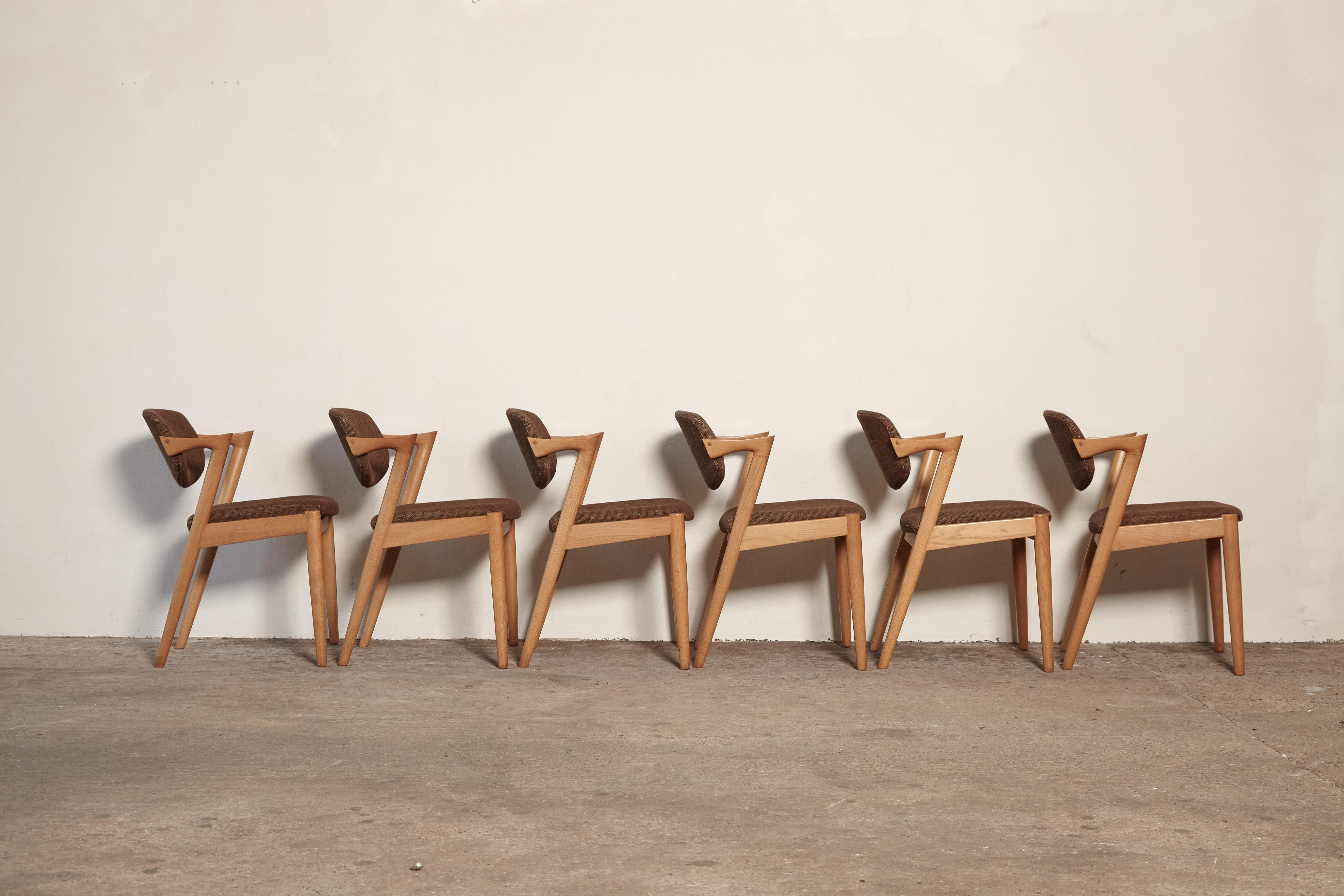 A set of six Model 42 oak dining chairs by Kai Kristiansen for Schou Andersen, Denmark. Tilting backrest. Original fabric seat covers - we offer a recovering service if you would like to replace the fabric.  Very good original condition.  Ships