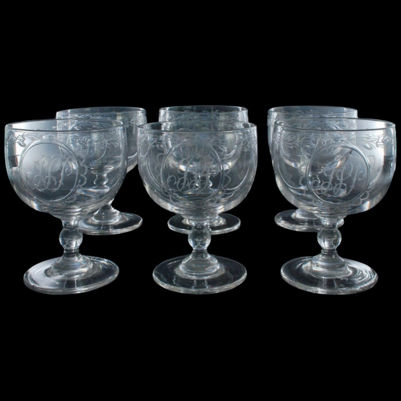 A set of six rummers, or wine glasses, beautifully engraved with leaves and branches and a monogram which seems to read JSP.

A rummer is a driking glass with a wide bowl, a short stem, and a wide foot. They are designed to be perfectly stable and