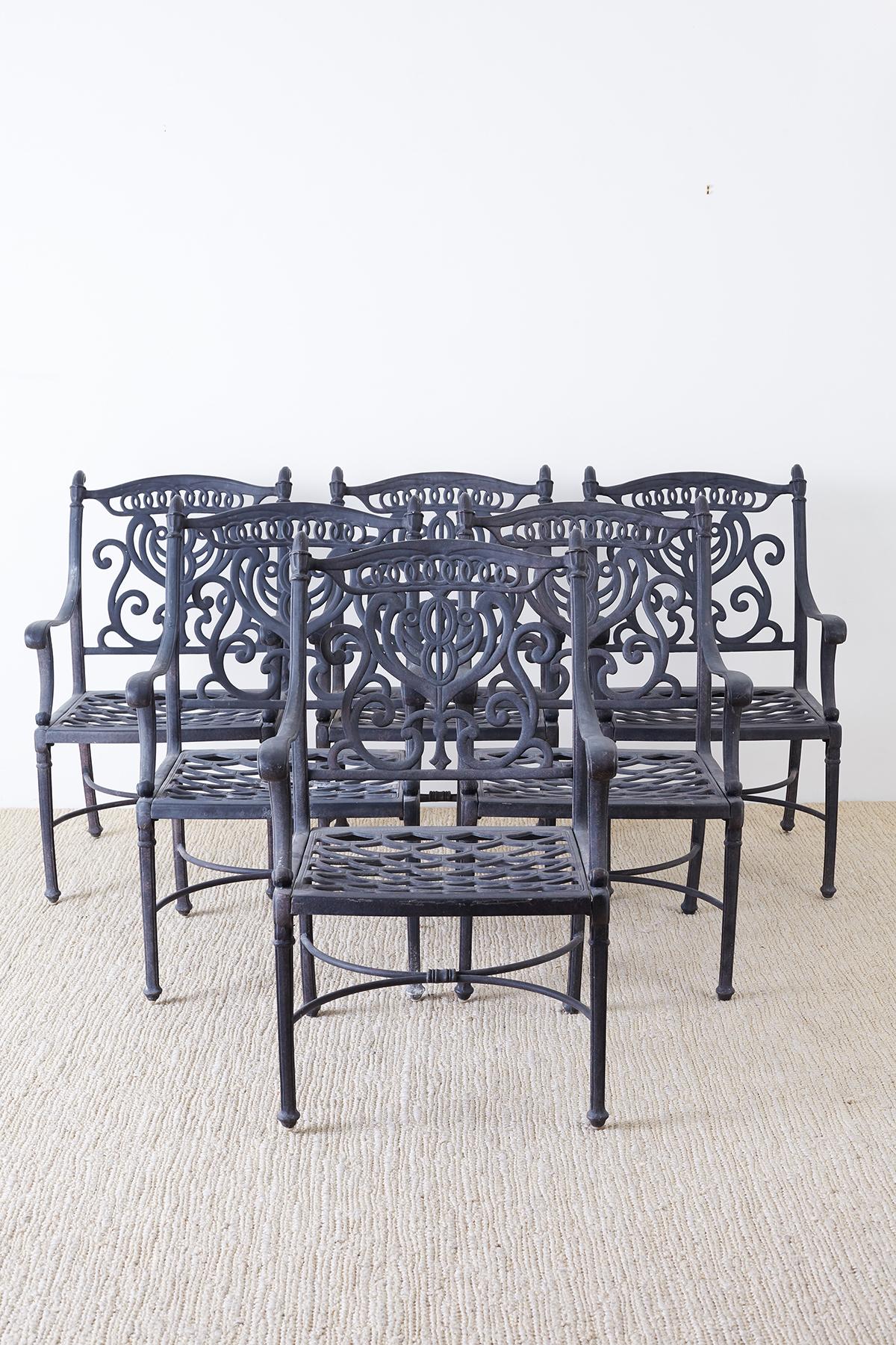 Fine set of six cast iron patio or garden chairs made in the neoclassical taste. Featuring a decorative scrolled lyre design on the back and graceful curved arms. Solid and heavy made in the U.S. with excellent joinery and craftsmanship. From an