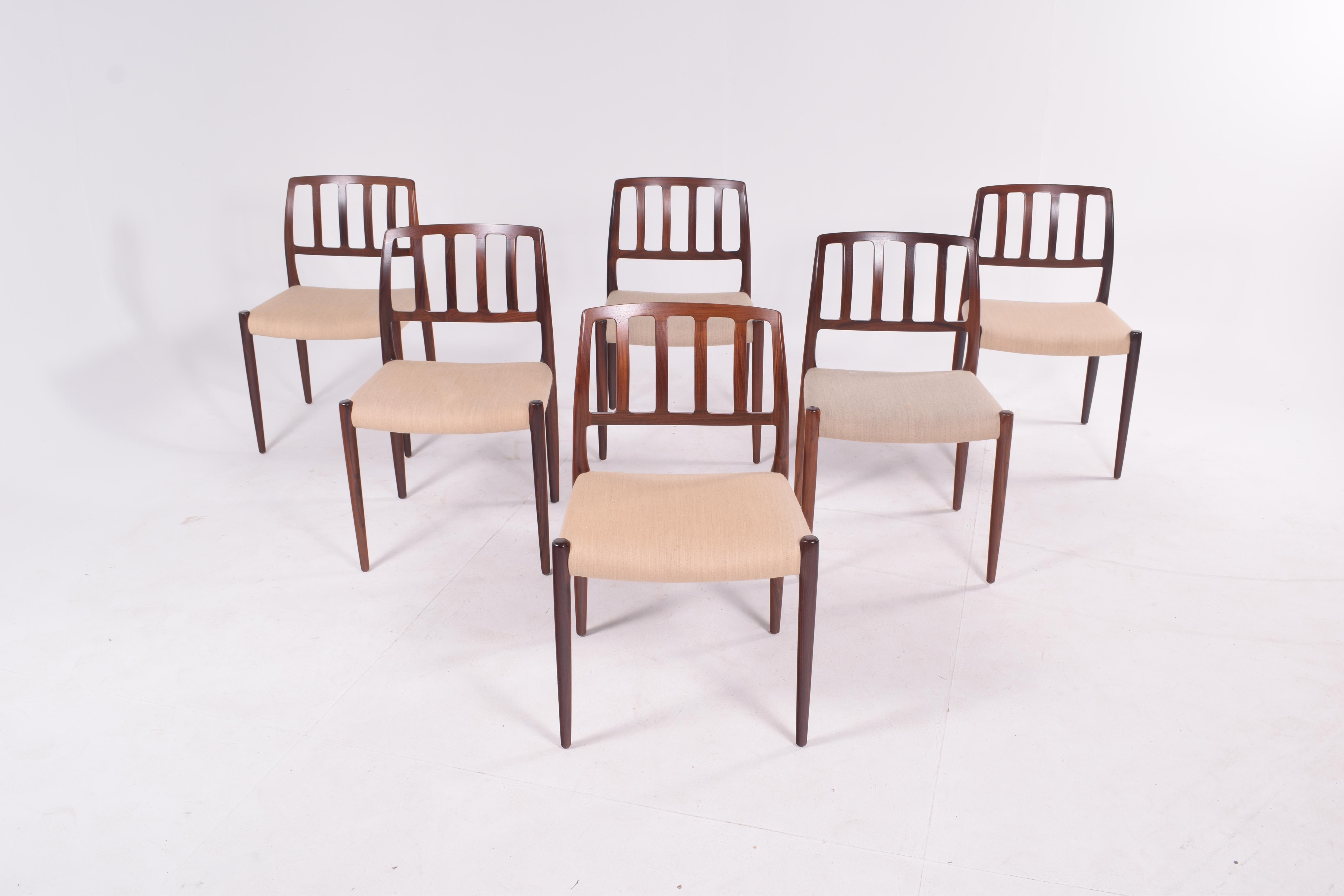 A six-piece set of “Model 83” upholstered rosewood dining chairs designed by Niels Otto Møller for J.L. Møller. Timeless Danish design features solid rosewood frame with smoothly sculpted back and emphatic front legs.