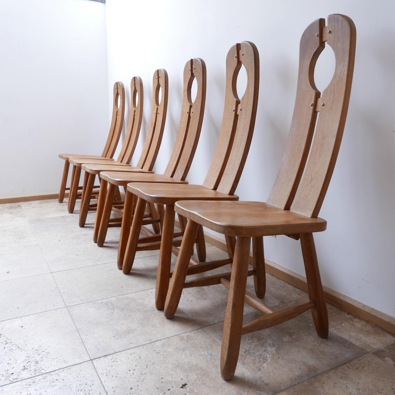 A set of scarce oak dining chairs. 

Belgium, c1970s. 

Solid oak. 

Elegant curves make these chairs comfy as well as stylish. 

Similar construction and look to De Puydt although we haven't seen this model before. 

Dimensions: 57 D x 42