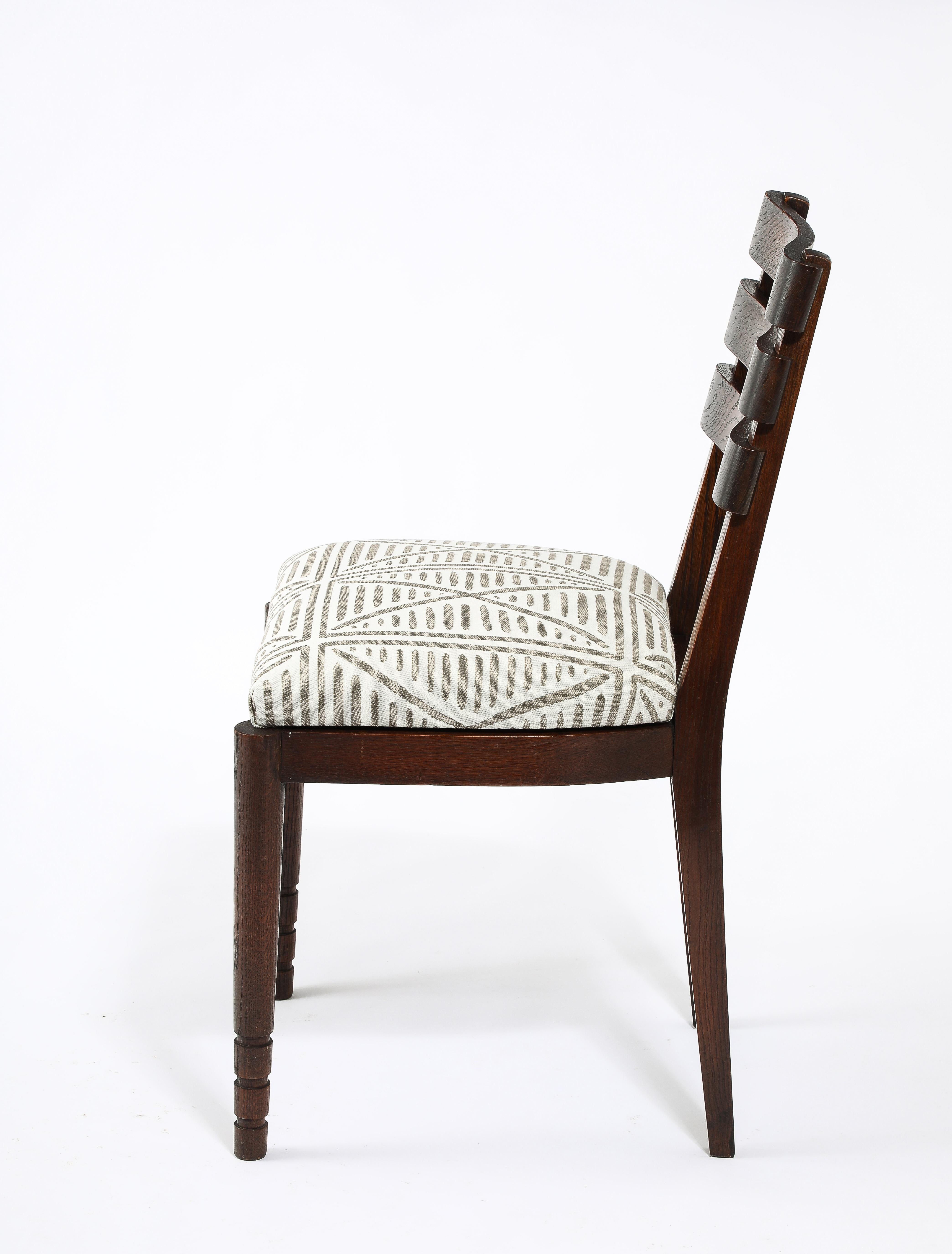 Curved slat backs dining chairs by Dudouyt in solid oak, original patina, a restrained almost art deco look for this designer.
