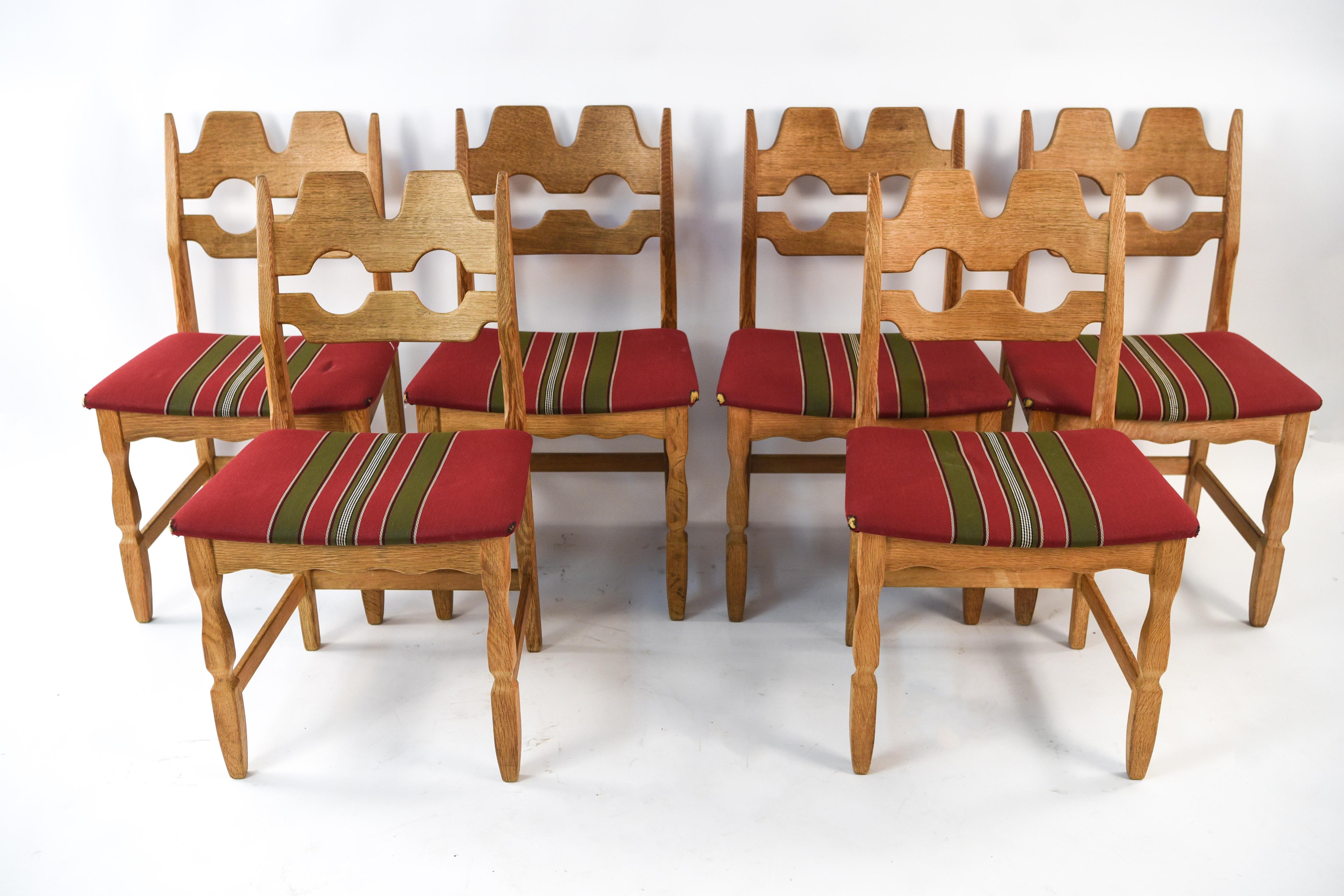 This is a wonderful, large set of eight dining chairs designed by Henning Kjaernulf in the 1960s. These sturdy chairs are made of solid oakwood and feature design elements of Baroque and midcentury style. Manufactured by Soro Stolefabrik.