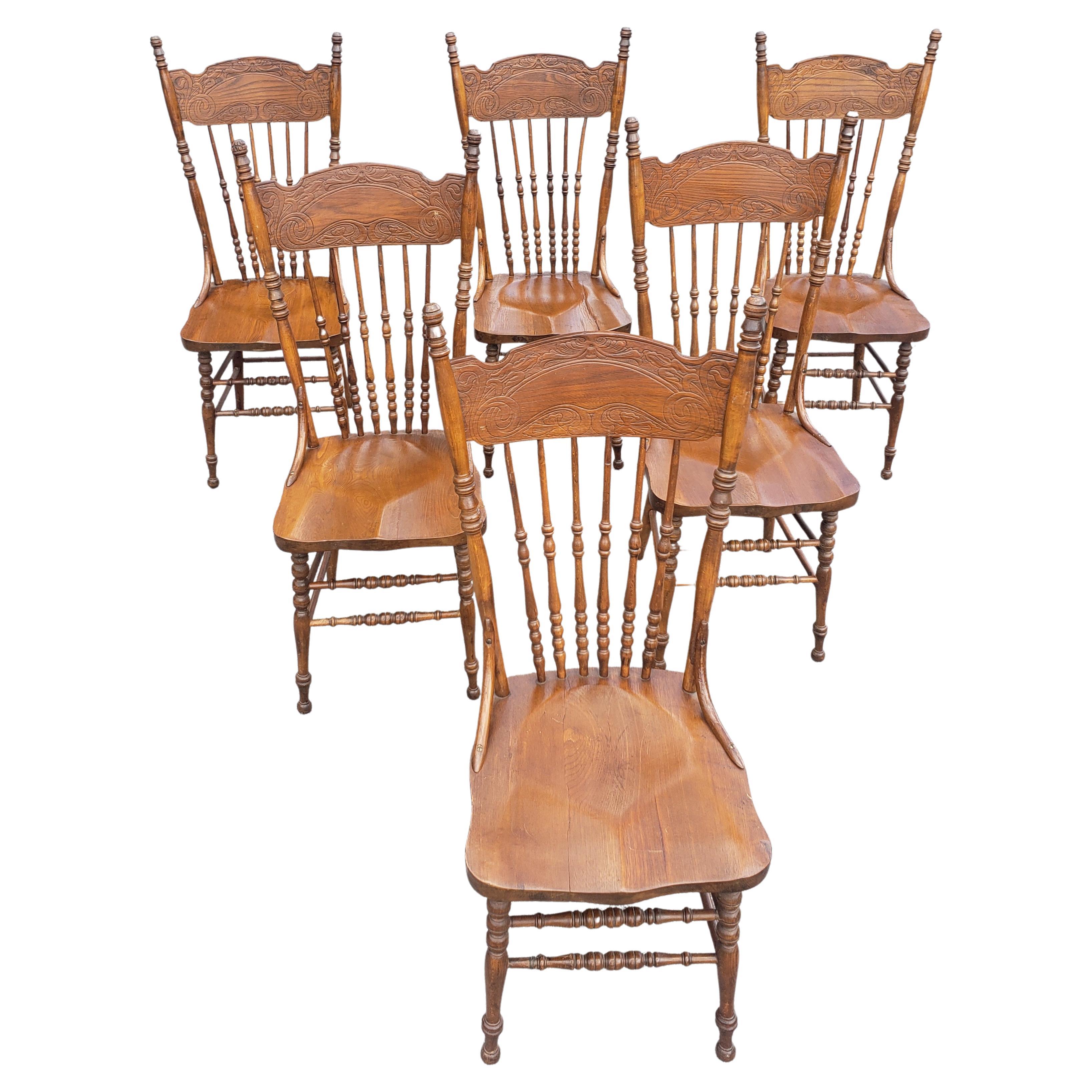 Ensemble de six chaises de salle à manger en Oak pressé et à dossier en fuseau avec assise en selle