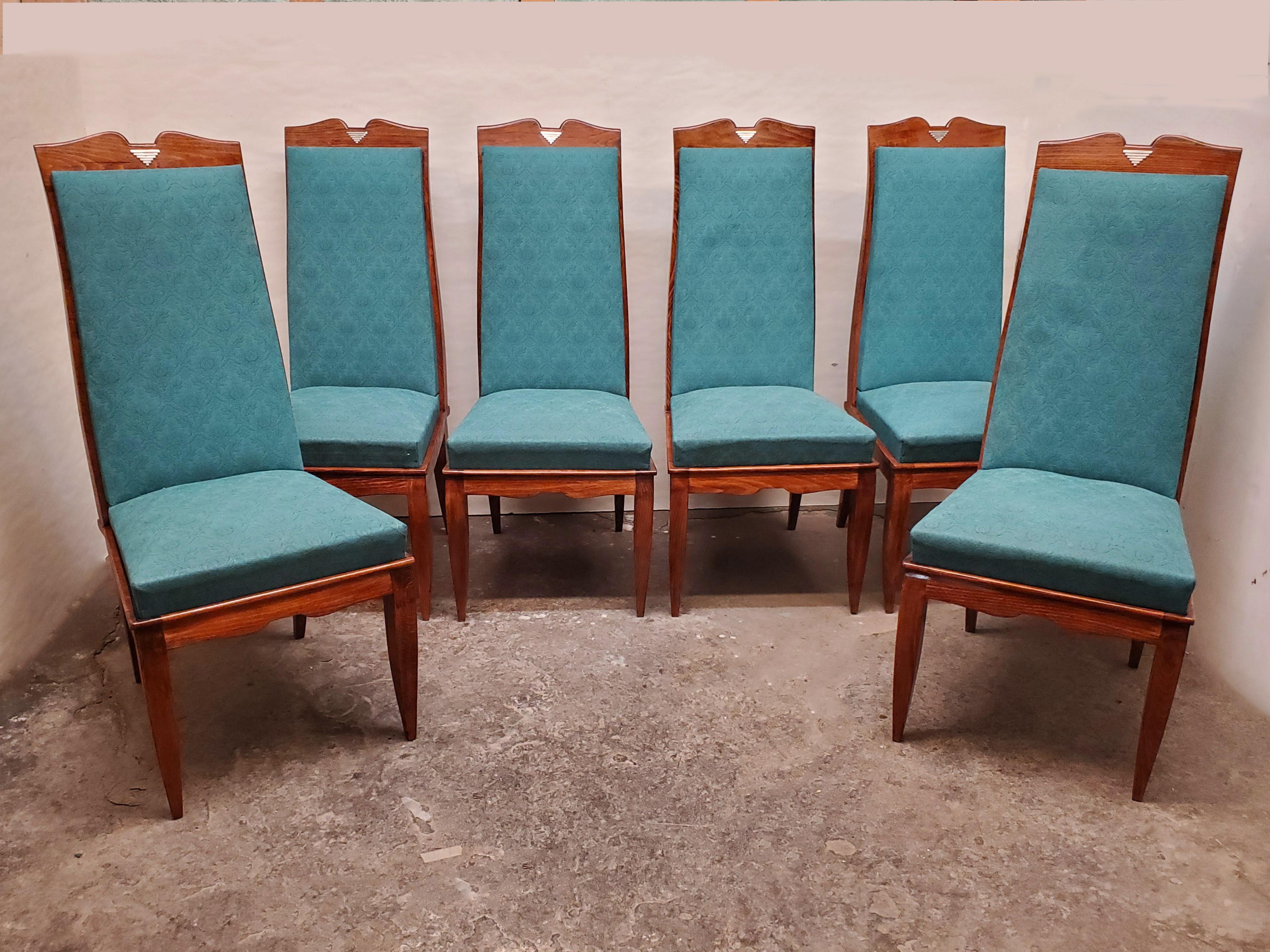 A set of six original French Mid-Century Modernist tall dining chairs featuring angular lines with a curved moustache shaped top, elegant tapered front cabriole legs and splay back legs.
The chairs are streamline in overall shape, featuring tall