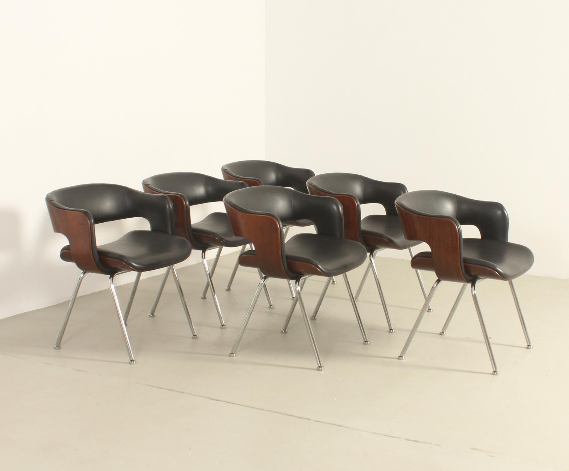 Set of six Oxford chairs designed in 1963 by British designer Martin Grierson for Arflex, Italy. Plywood molded shell upholstered in original black vinyl and polished steel bases.