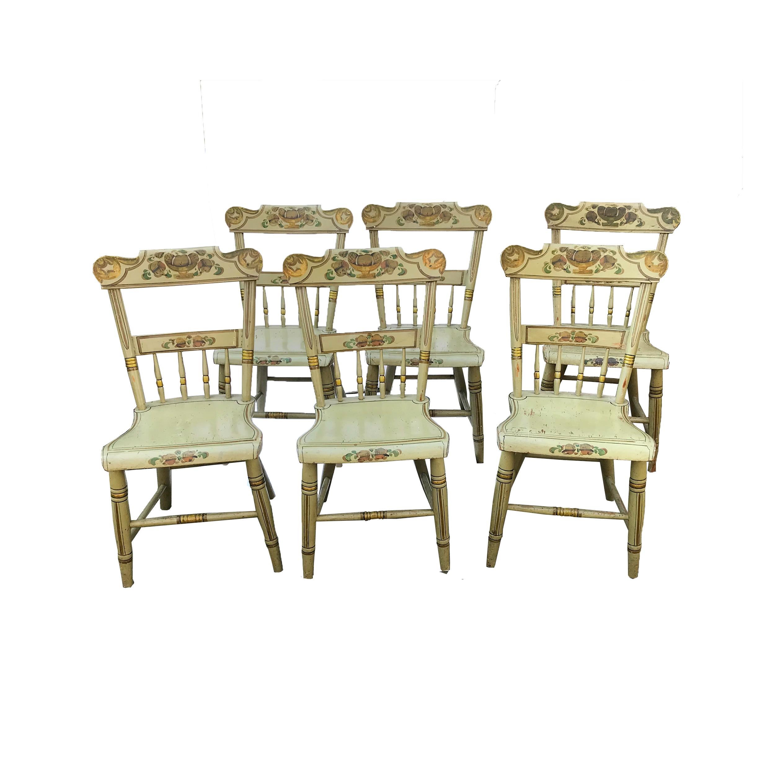 Set of six paint decorated plank seat chairs, each with a rectangular rolled crest rail with half spindle back and shaped plank seat. The cylindrical tapered legs are splayed with a stretcher. The splat, slat and seat rail are decorated with painted