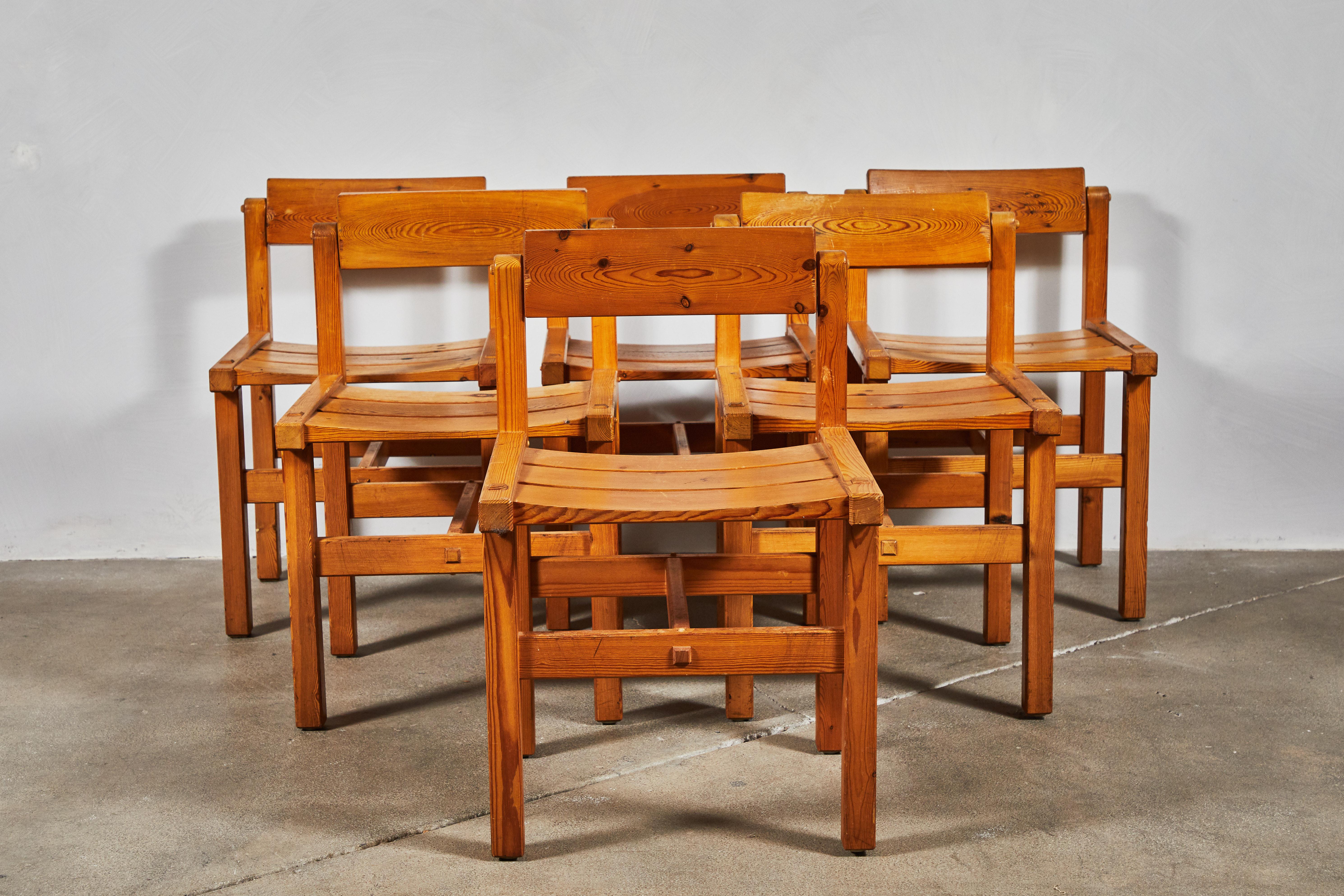 Set of six unique pine dining chairs with slatted seats and rotating backs.