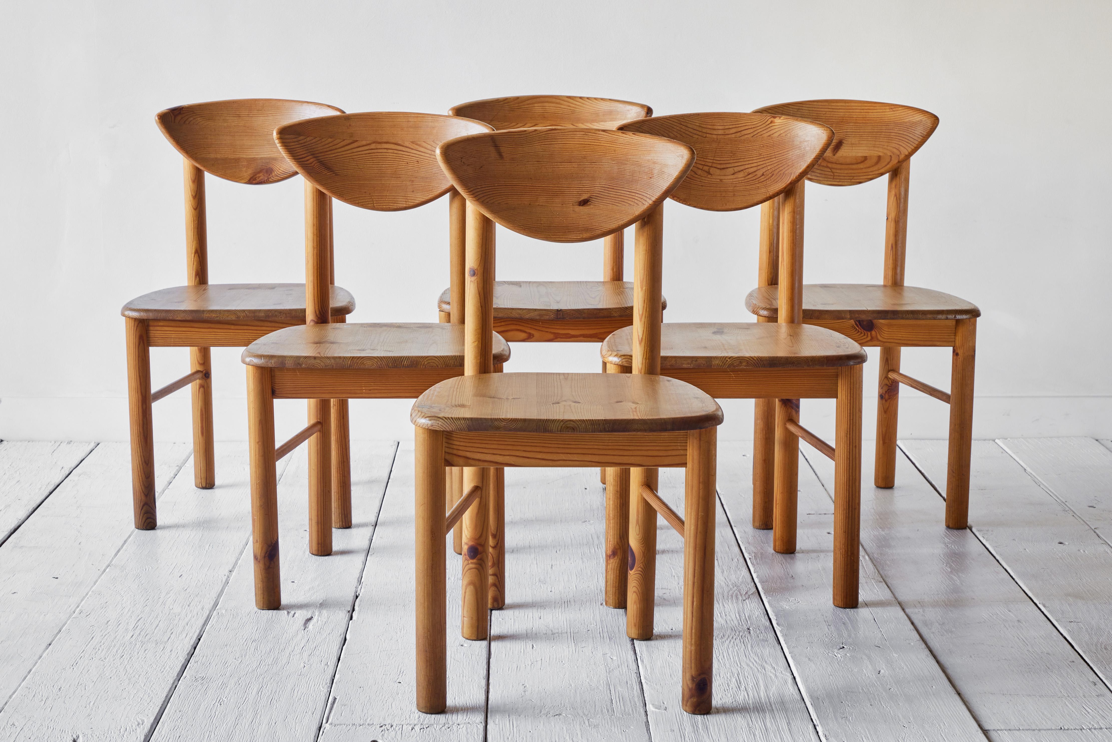 Set of six solid pine wood chairs designed by Rainer Daumiller and manufactured by Hirtshals Savvaerk in the 1970s. The chairs have a carved seat and backrest which give them a robust and organic appearance. The rustic pine wood boasts a rich and