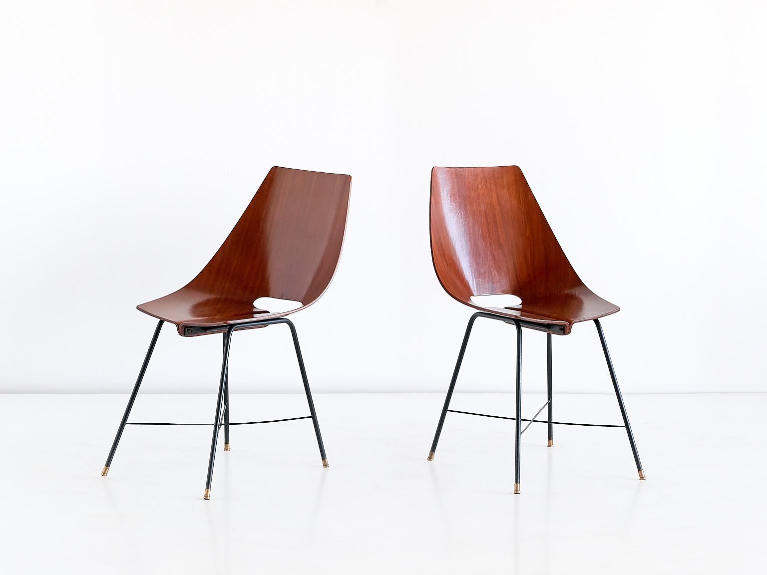 This rare set of six dining chairs was manufactured by Societá Compensati Curvati in Monza, Italy in 1959. The chairs feature a teak plywood shell seat mounted on a black metal crossed base. This striking design was numbered model 127-B by the