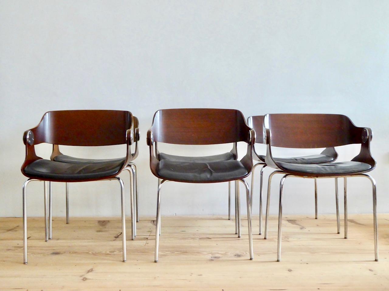These armchairs were designed and manufactured 1966 by German architect Eugen Schmidt for exclusive surroundings. The chairs feature plywood seats and backs, a chromed metal base and original black leather upholstery seats.