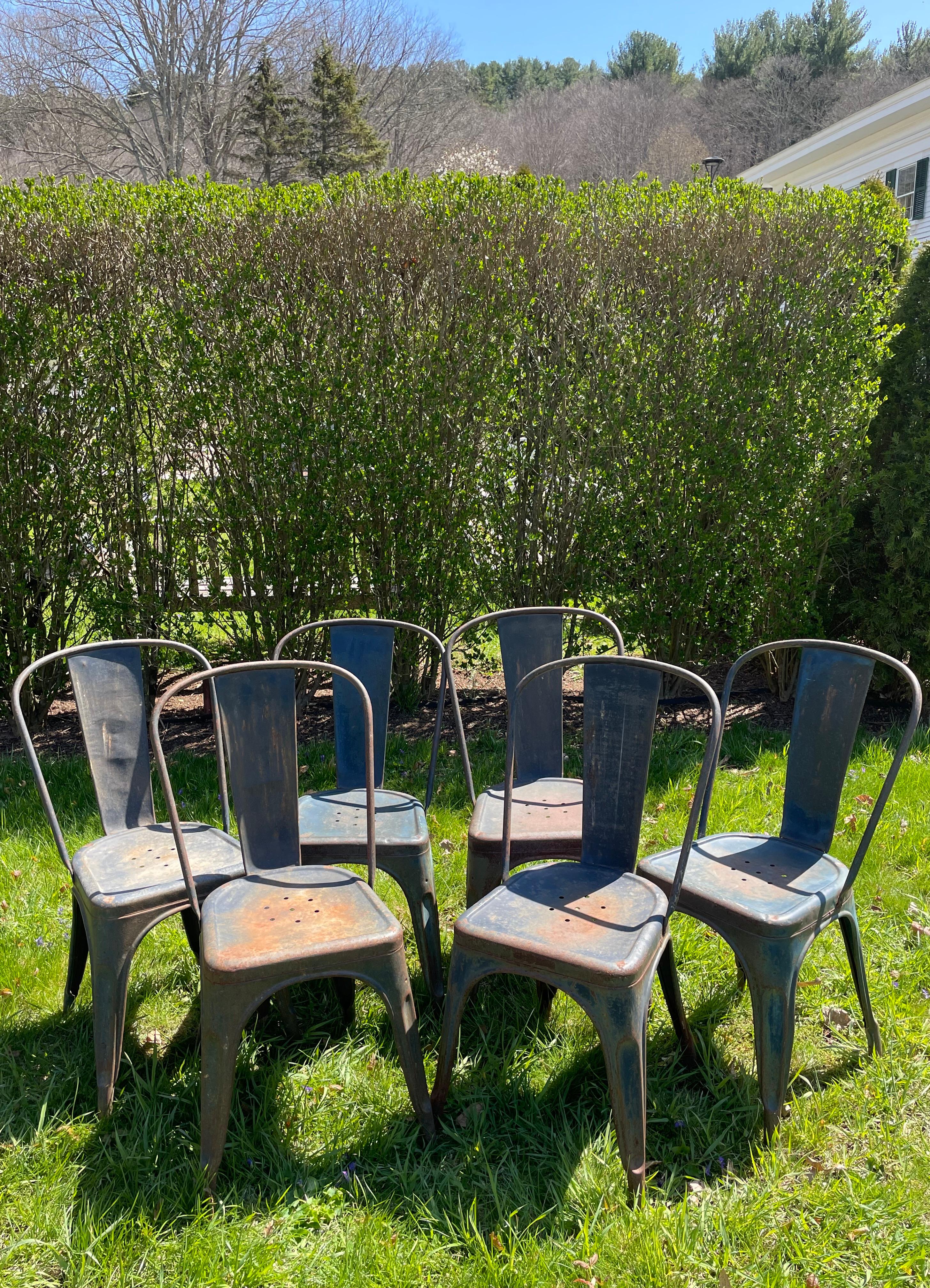 This wonderful set of six Tolix Model A metal dining chairs is in excellent condition and features its original lovely dark blue paint with a bit of surface rusting. Originally designed in 1934 by the founder of Tolix, Xavier Pauchard, this chair