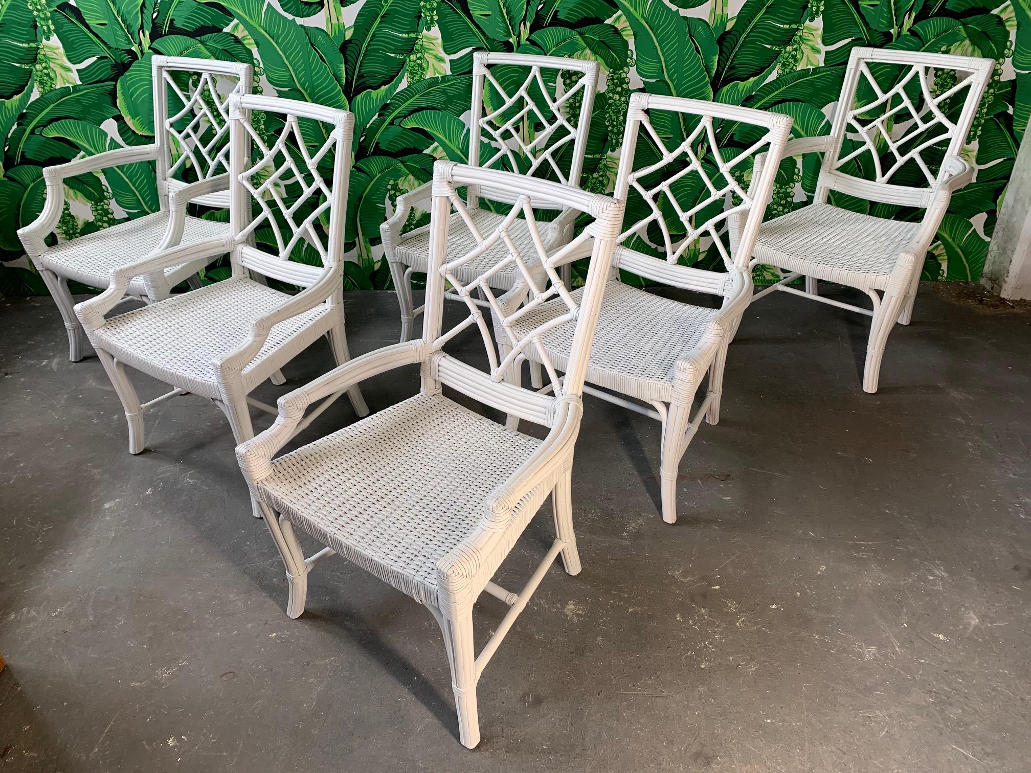 Set of 6 faux bamboo rattan dining chairs in Asian chinoiserie style. Wicker seats and leather wrapped joints. Four side chairs and two armchairs. Very good condition both structurally and cosmetically.