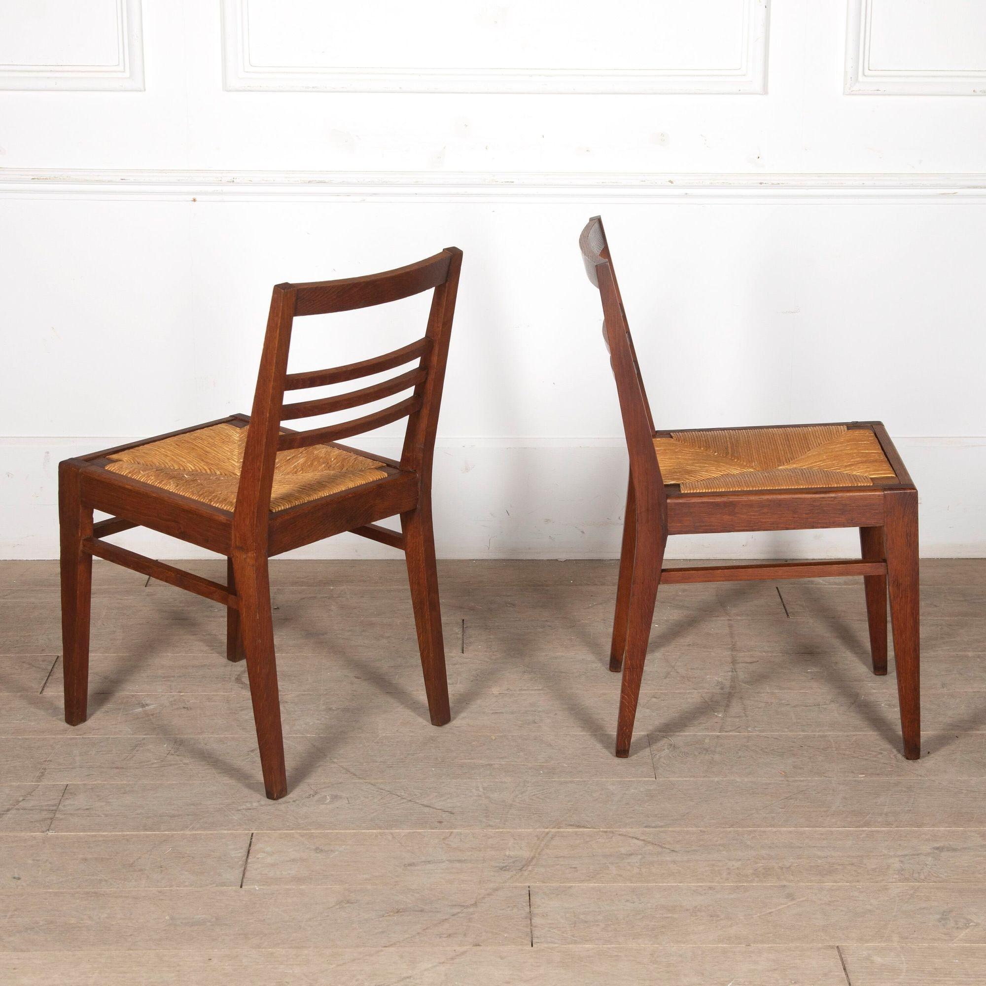 Joli ensemble de six chaises de salle à manger en chêne du milieu du siècle avec des sièges en jonc par Rene Gabriel.
Vers les années 1950.