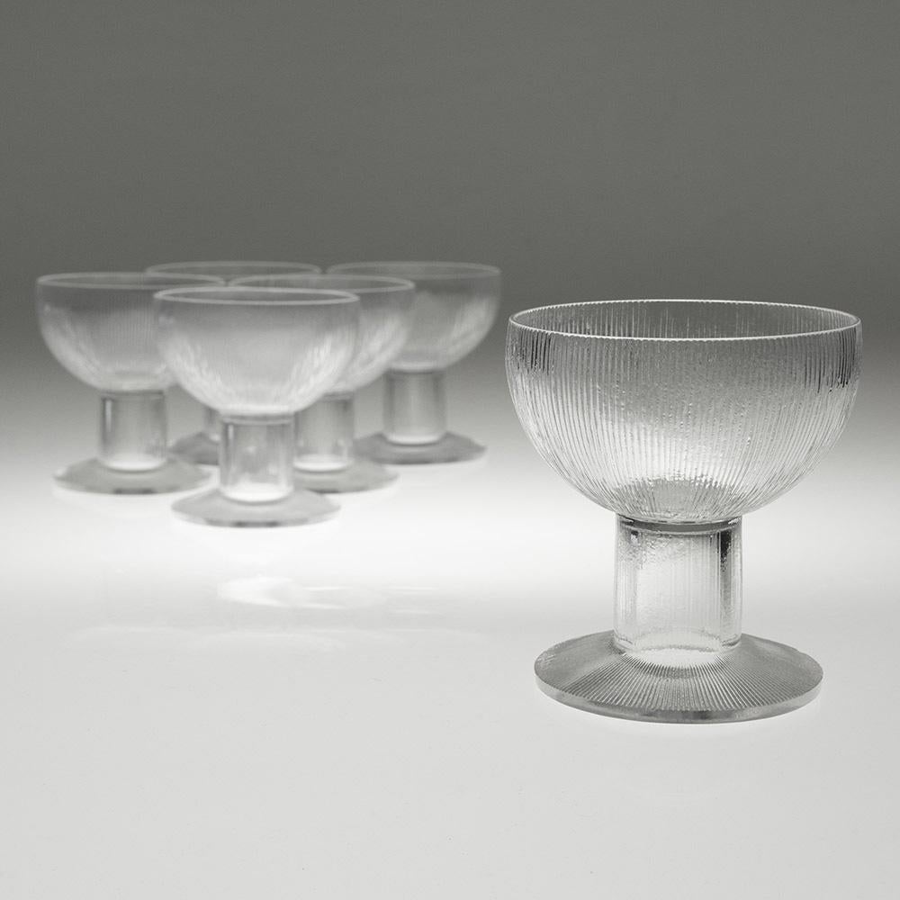 Encabezamiento : René Lalique Champán Coupes Patrón Wingen
Periodo : Diseñado en 1926. no continuó después de 1947
Origen : Wingen-sur-Moder. Alsacia. Francia
Color : Transparente
Cuenco : En forma de taza
Tallo : Hueco. abierto hacia el pie
Pie :