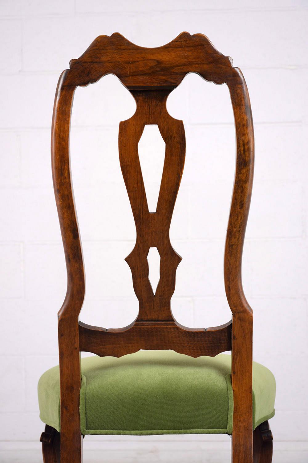 This set of six 1900s Regency style dining chairs feature high backs with hand carved frames with stretched legs stained a walnut color. The frames have carved details, completely restored seats with comfortable cushions, and have been