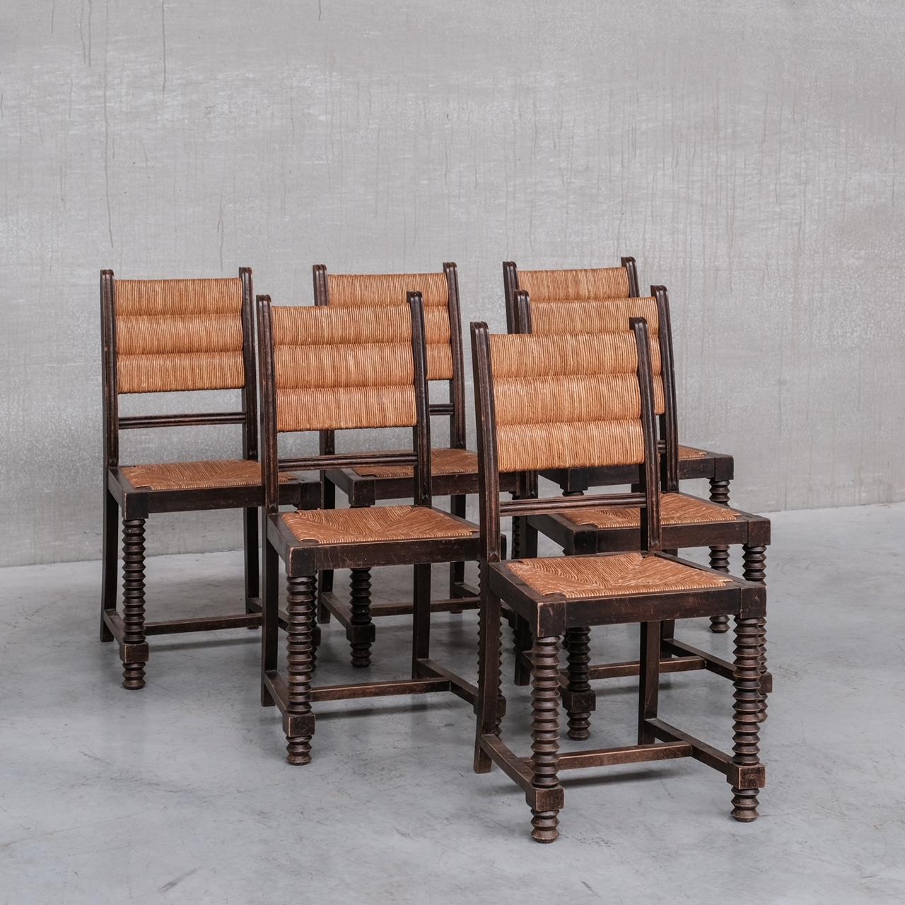 A set of six mid-century rush dining chairs. 

France, c1950s. 

Oak turned frames with particularly good legs in the manner of Charles Dudouyt. 

Original rush seats and back rests, they remain in generally good condition but there is wear