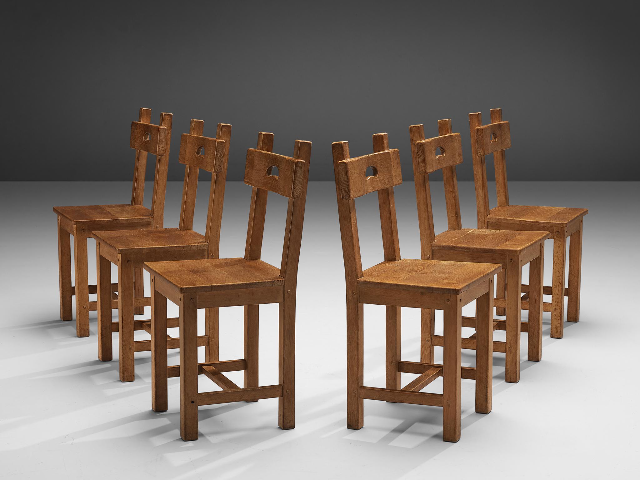 Set of six dining chairs, oak, France, 1950s

Characteristic set of French dining chairs. In absence of decoration the rounded gap in the backrest gets an important visual role as it contrasts with the sharp, angular lines of the frame and seat.