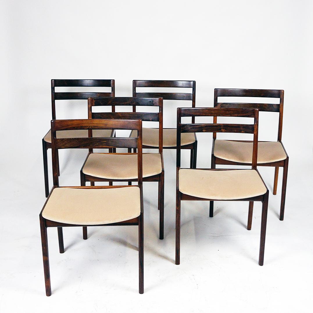 This exclusive set of six Scandinavian Modern Dining chairs was designed in the middle of the last century by the Danish Henry Rosengren Hansen for the BM (Brande Møbelindustri) label. 
Solid rosewood frame and lighz beige velvet upholstered seat: