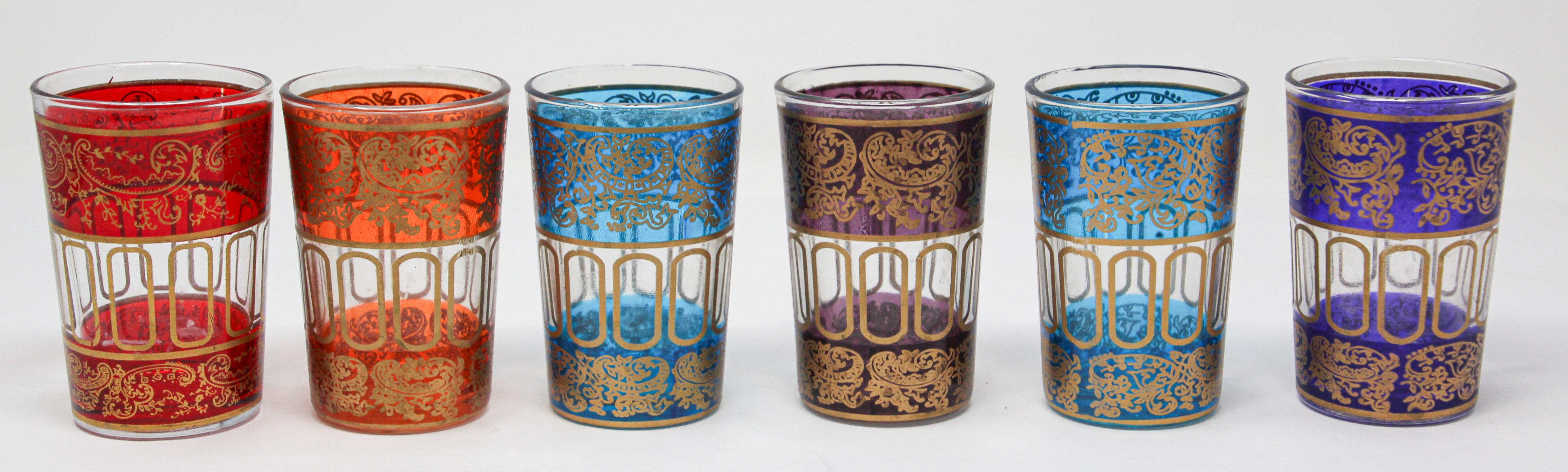 Set of six shot Moroccan colored glasses with gold raised Moorish design.
Decorated with a classical gold and pattern Moorish frieze.
One red, one purple, one orange, two blue, one violet.
Use these elegant glasses for Moroccan tea, or any hot or